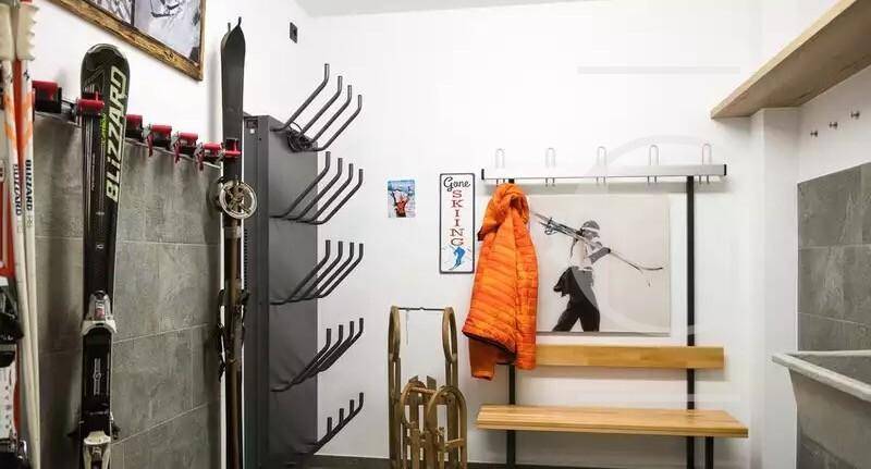Praktischer Abstellraum für Skiausrüstung mit Regalen und Sitzbank.