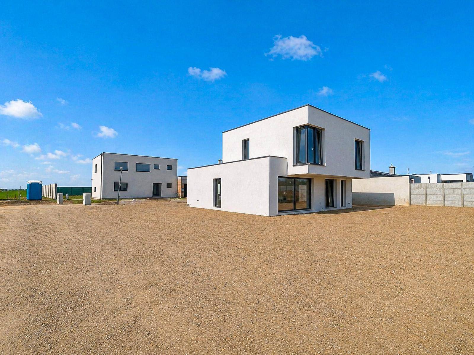 Weitläufige Ansicht des modernen Neubaus in einer neuen Siedlung unter blauem Himmel.