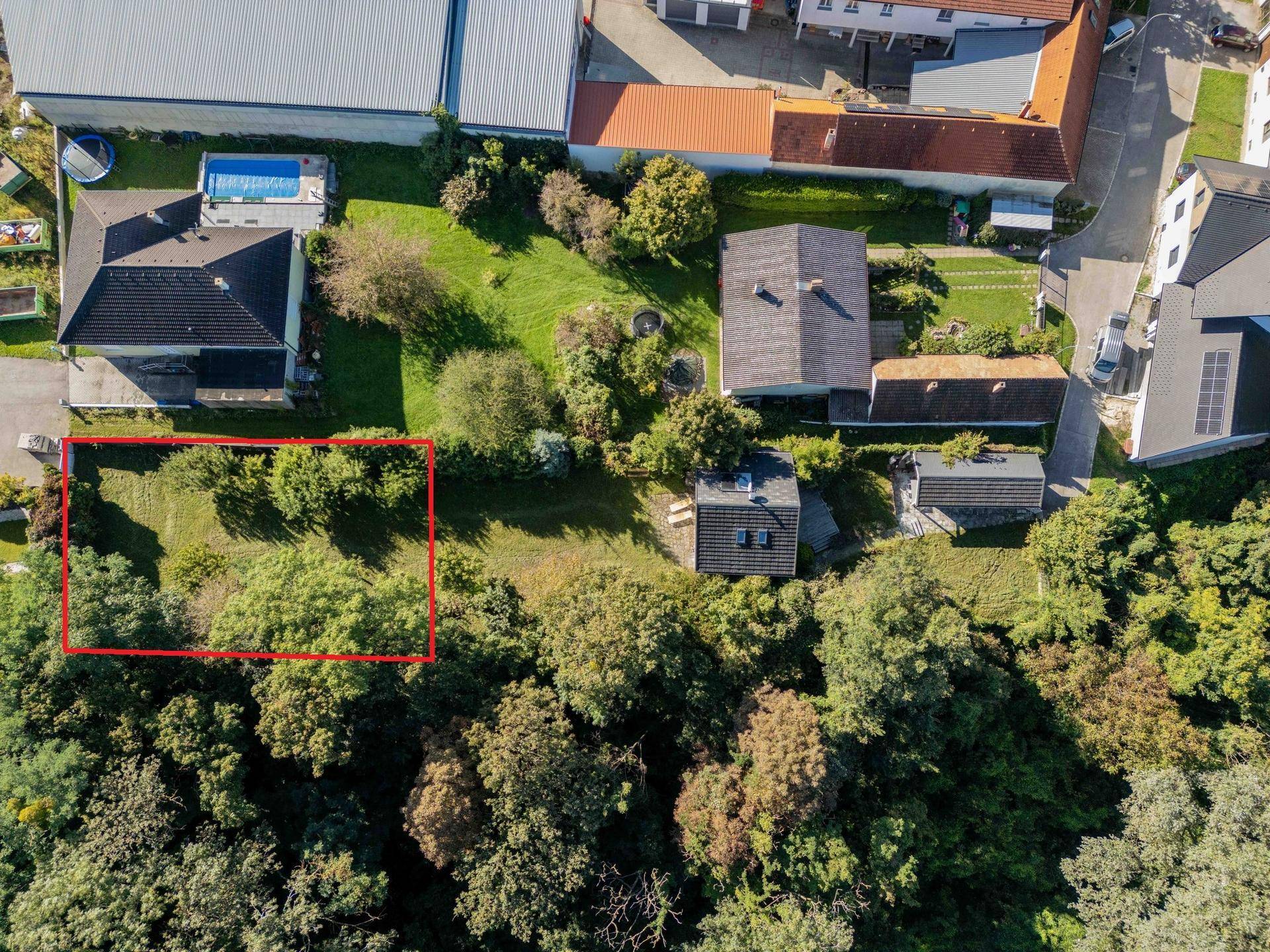 Nähere Luftaufnahme des Grundstücks mit angrenzenden Wohnhäusern und einem Pool in der Nachbarschaft.