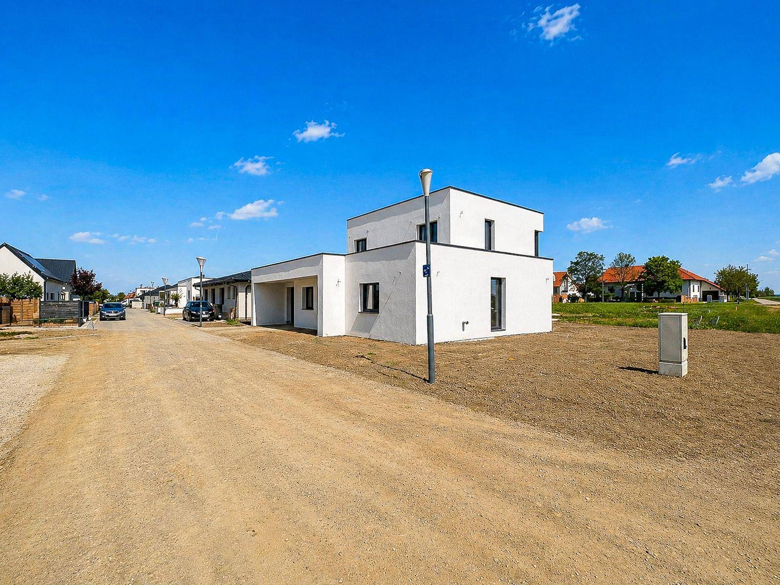 Modernes Einfamilienhaus im Neubaugebiet mit klarer Architektur und unfertigem Vorgarten.