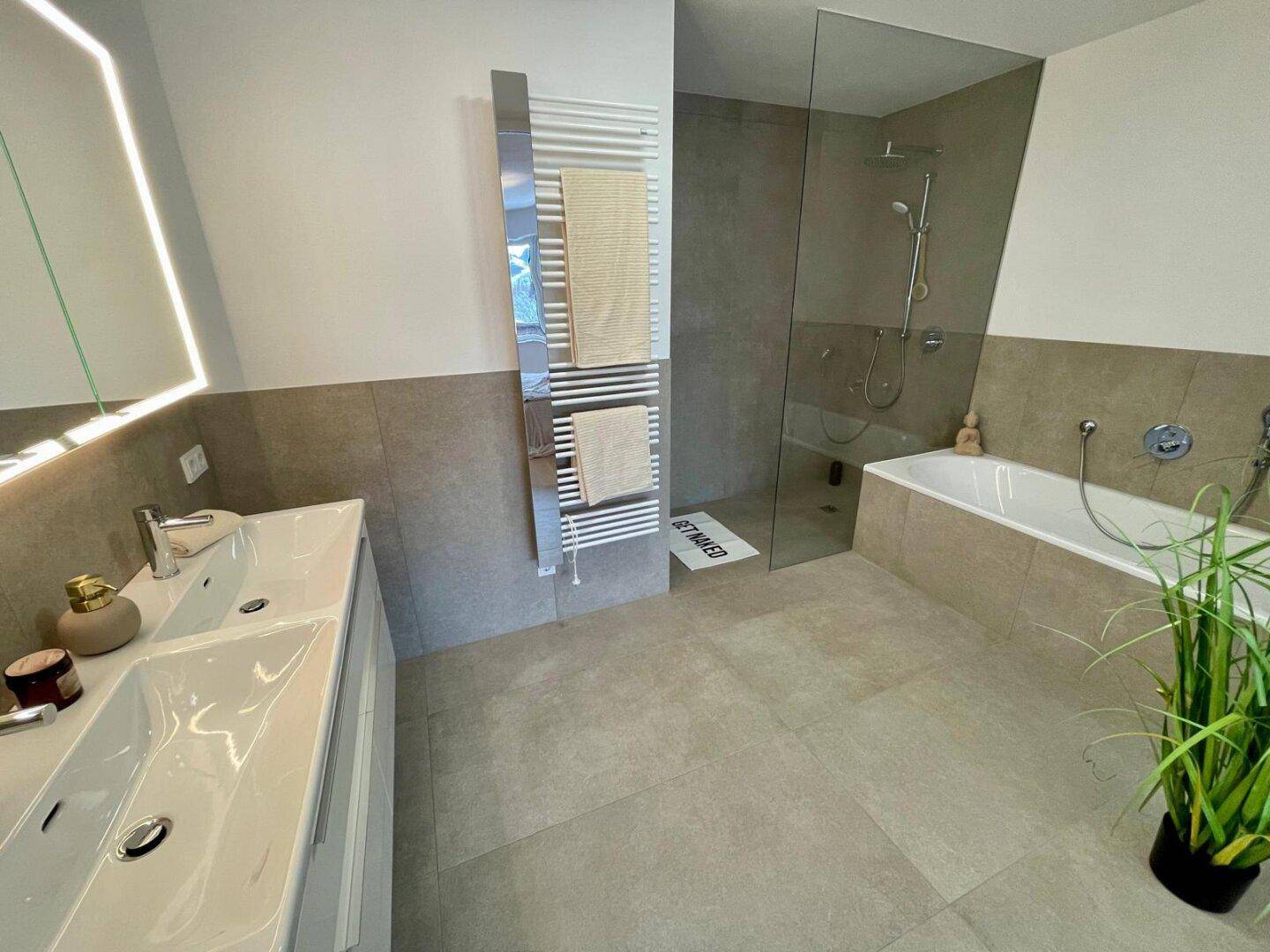 Modernes Badezimmer mit Doppelwaschbecken, begehbarer Dusche und Badewanne.