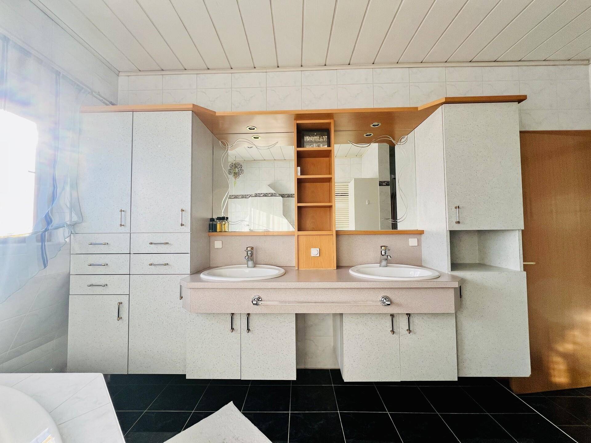 Badezimmermöbel mit Doppelwaschbecken, Spiegelschrank und viel Stauraum.