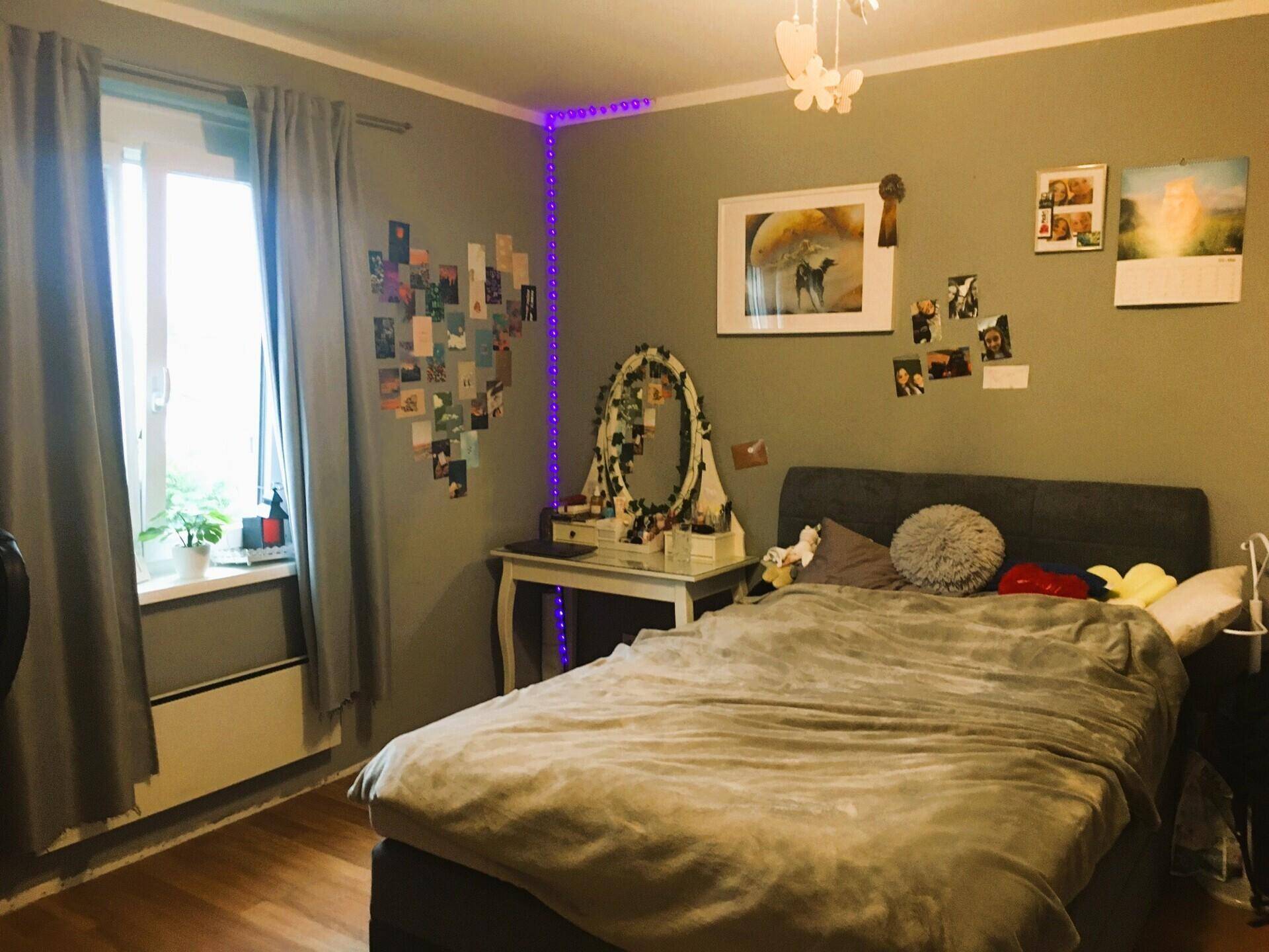 Gemütliches Schlafzimmer mit Doppelbett, Schminktisch und dekorativer Beleuchtung.