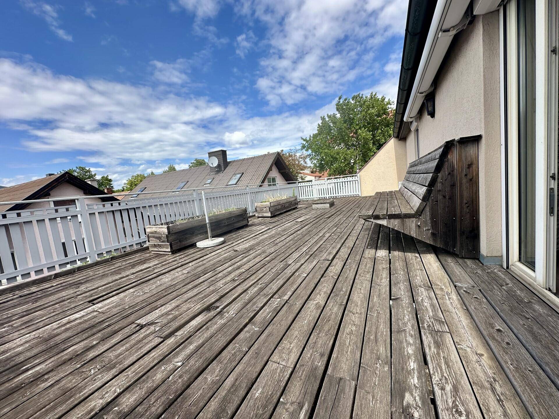 Geräumige Holz-Dachterrasse mit integrierter Sitzbank und weitem Blick.