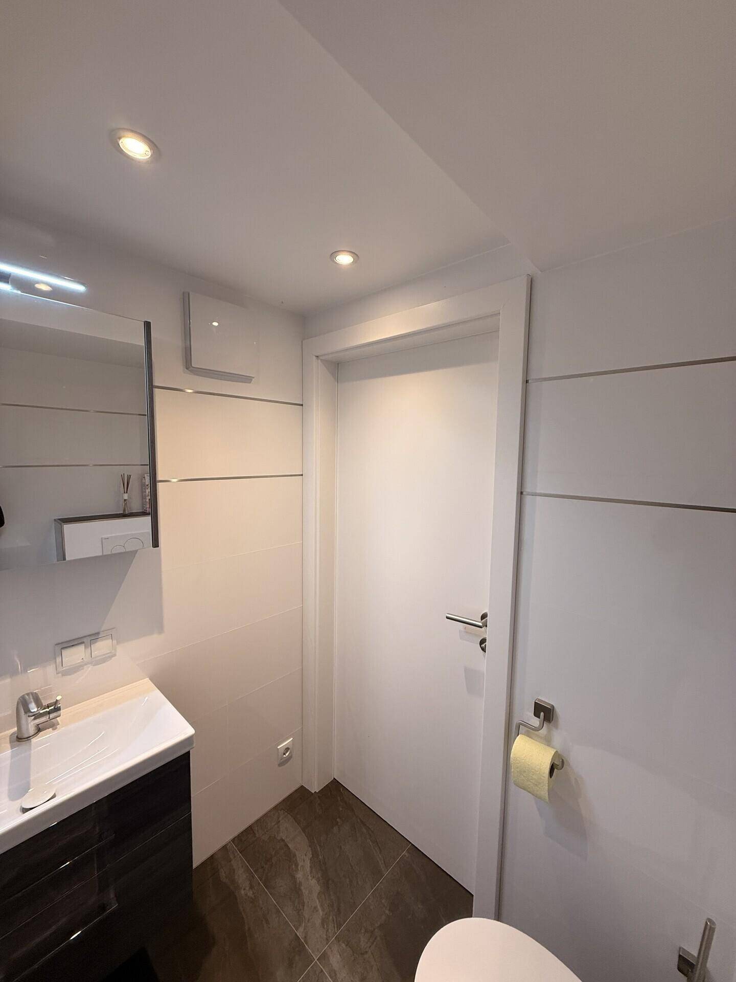 Funktionales Gäste-WC mit Spiegel und moderner Ausstattung, ideal für Besucher.
