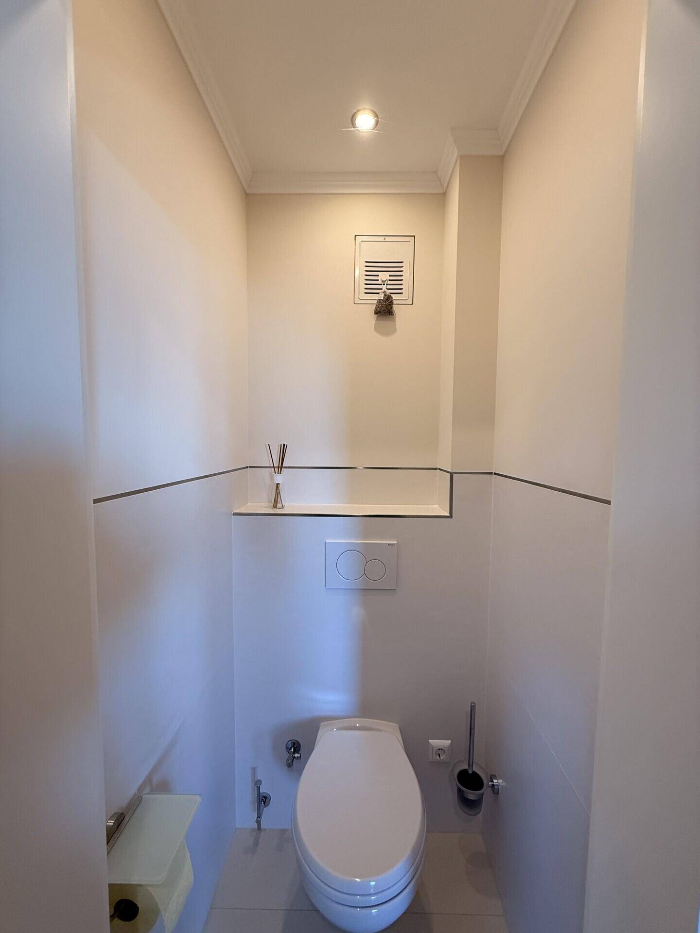 Kleines, helles Gäste-WC mit wandhängendem WC und minimalistischem Design.