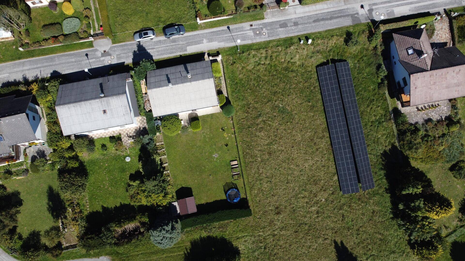 Überblick über das Grundstück mit Haus, Garten, Straße und angrenzender Photovoltaikanlage.