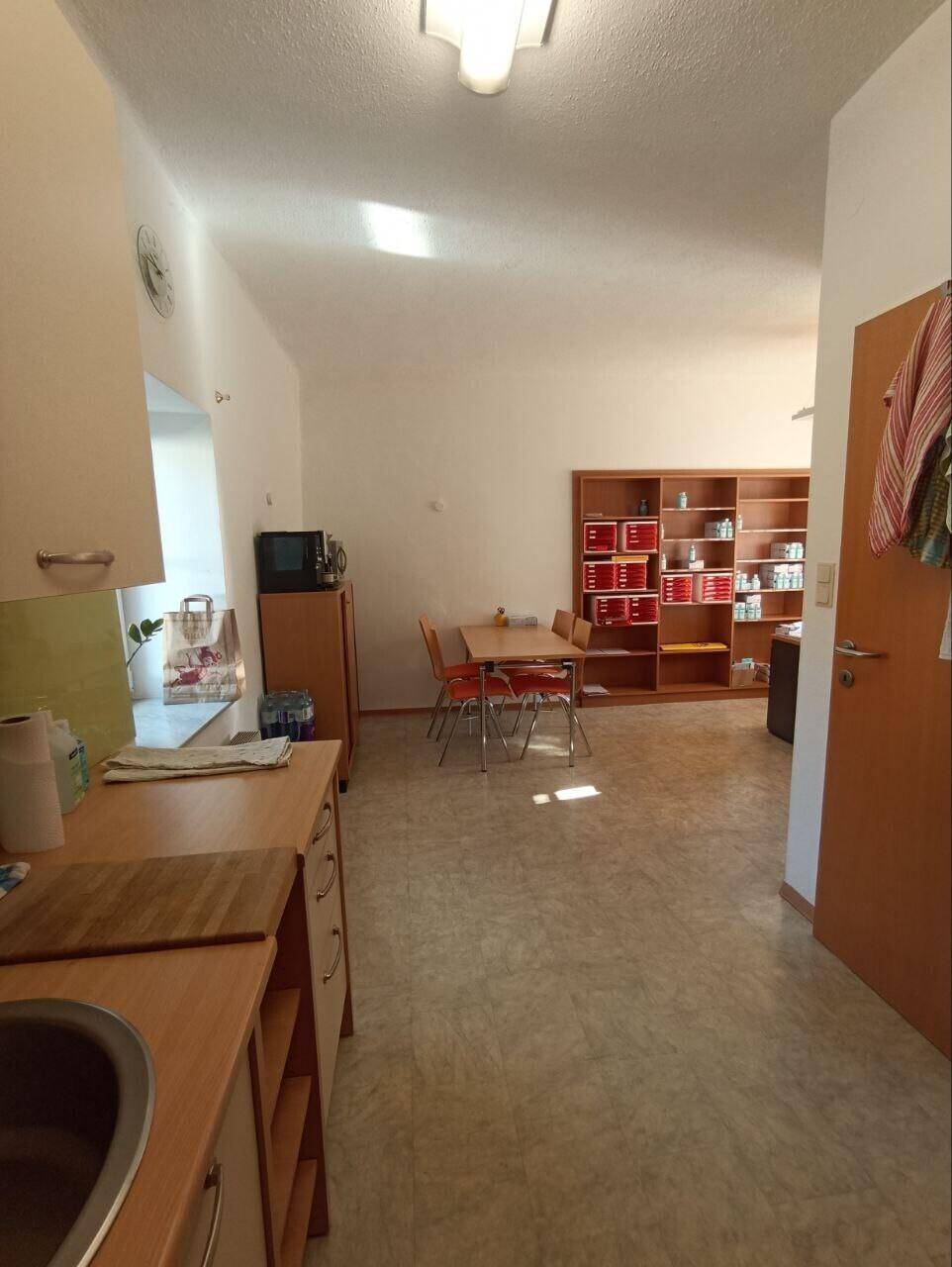 Kleine Küche oder Teeküche mit Essbereich und Holzmöbeln.