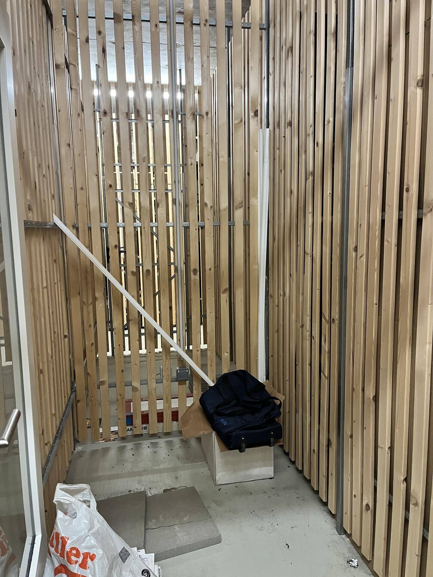 Innenbereich mit Holzlattenverkleidung, möglicherweise ein Fahrradraum oder Abstellbereich.