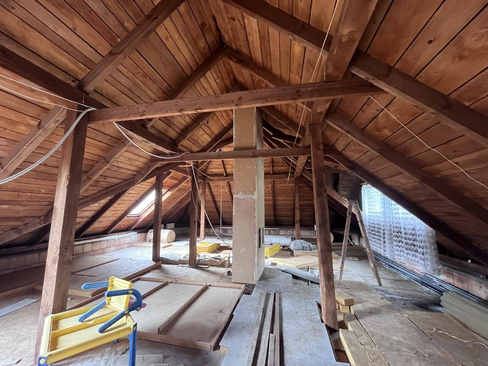 Unausgebauter Dachboden mit sichtbaren Holzbalken und Dachschrägen, bietet Ausbaupotenzial.