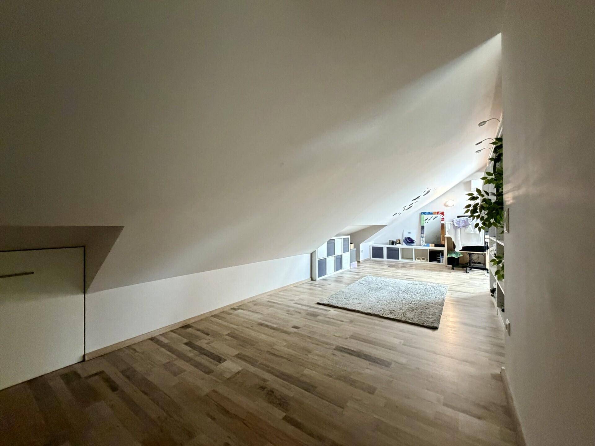 Heller Dachbodenraum mit Laminatboden und Schrägen, vielseitig nutzbar.