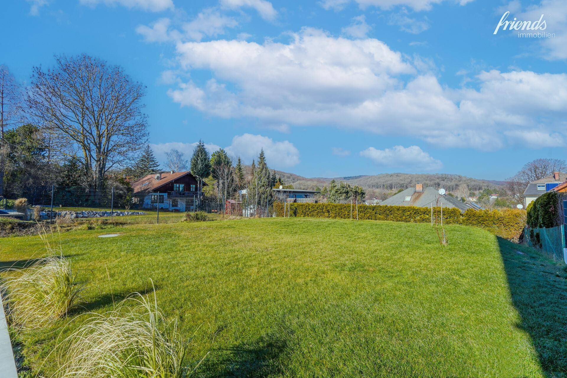 Große, gepflegte Rasenfläche mit Blick auf die umliegende Landschaft und Häuser.