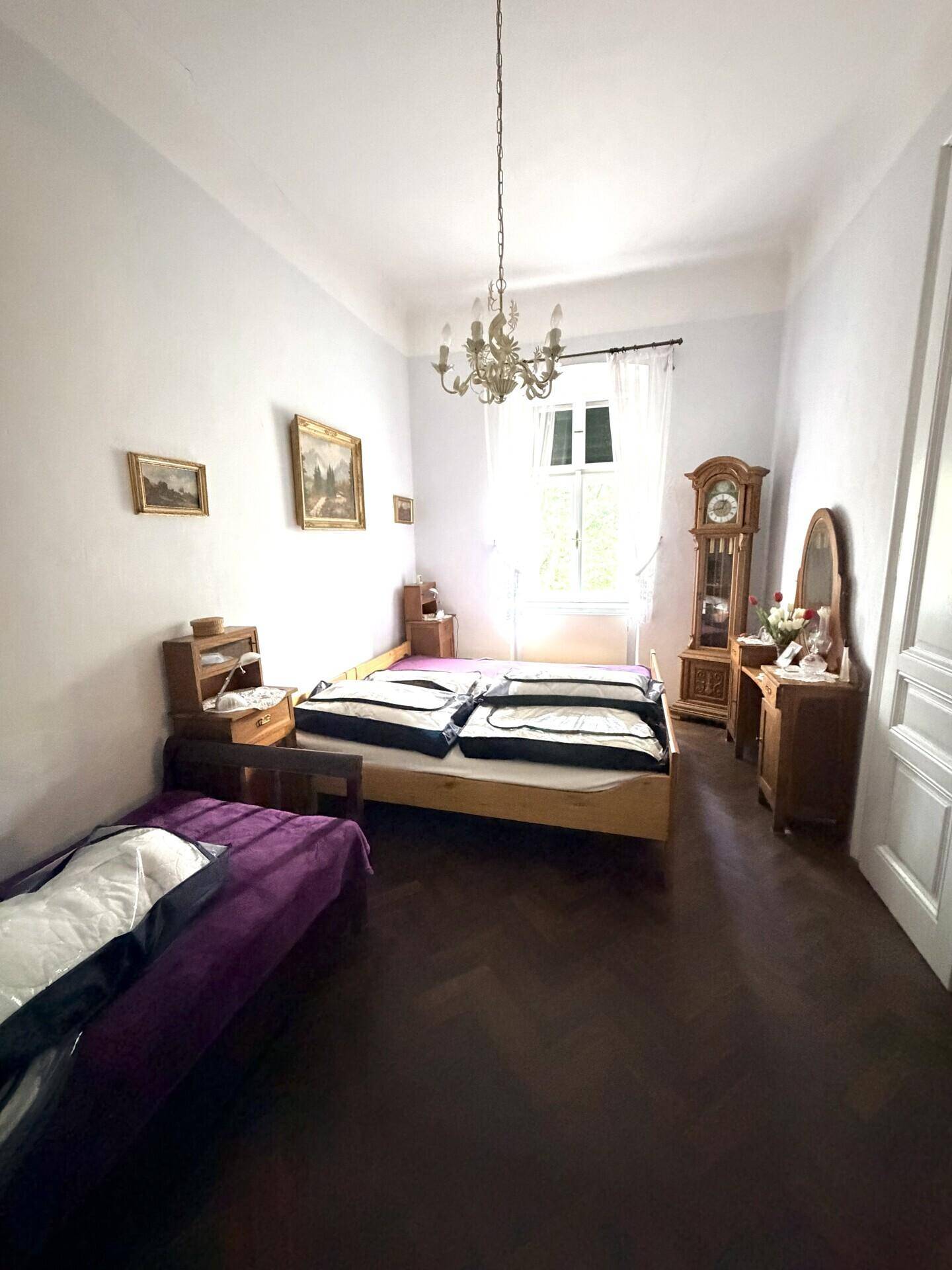 Geräumiges Schlafzimmer mit zwei Einzelbetten, hellem Interieur und einem großen Fenster für natürliches Licht.