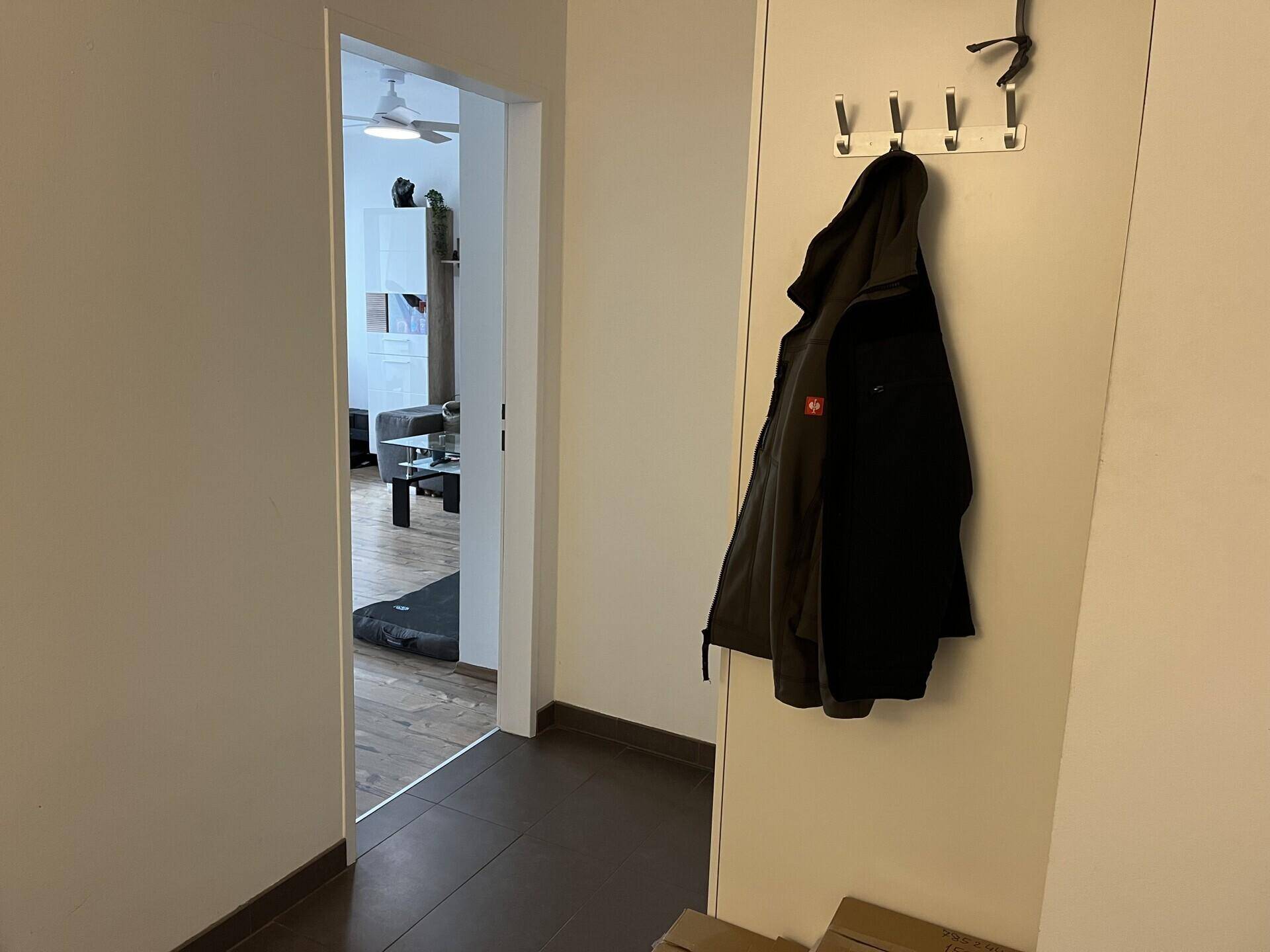 Heller Flur mit Garderobe und Blick in den angrenzenden Wohnbereich der Wohnung.