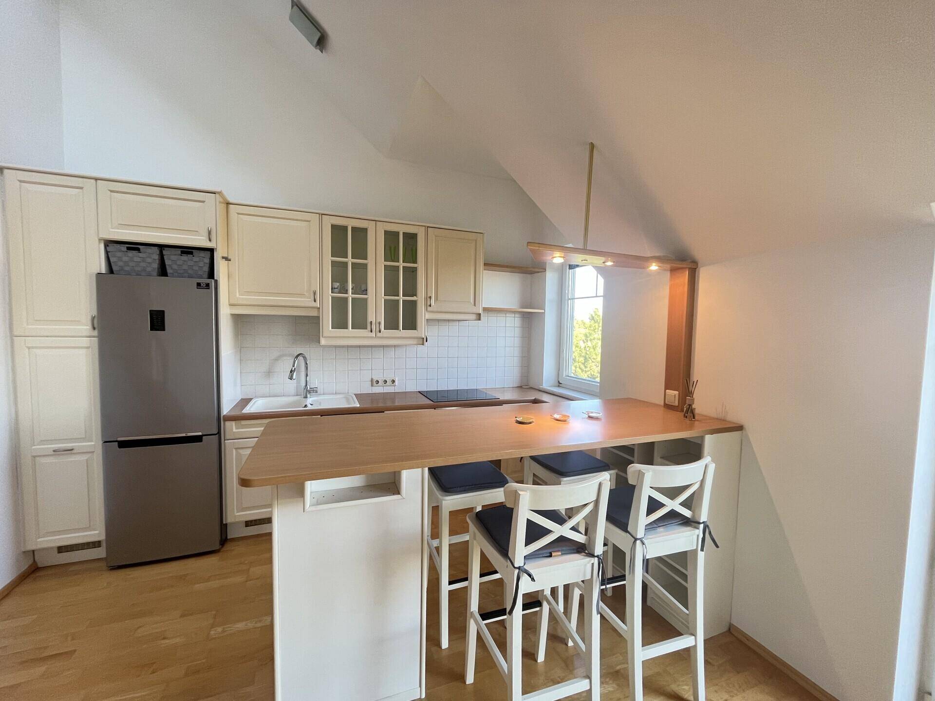 Funktionale Einbauküche mit Frühstücksbar, modernen Geräten und Fenster.