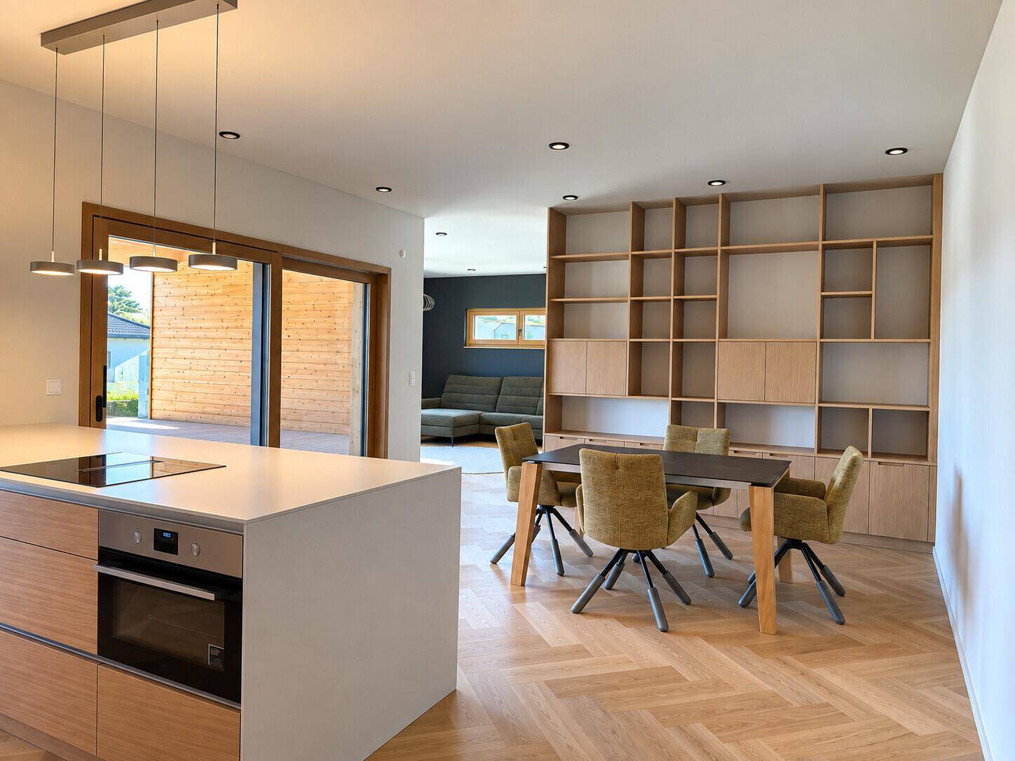 Offener Wohn- und Essbereich mit moderner Küche, Holzboden und Zugang zur Terrasse.