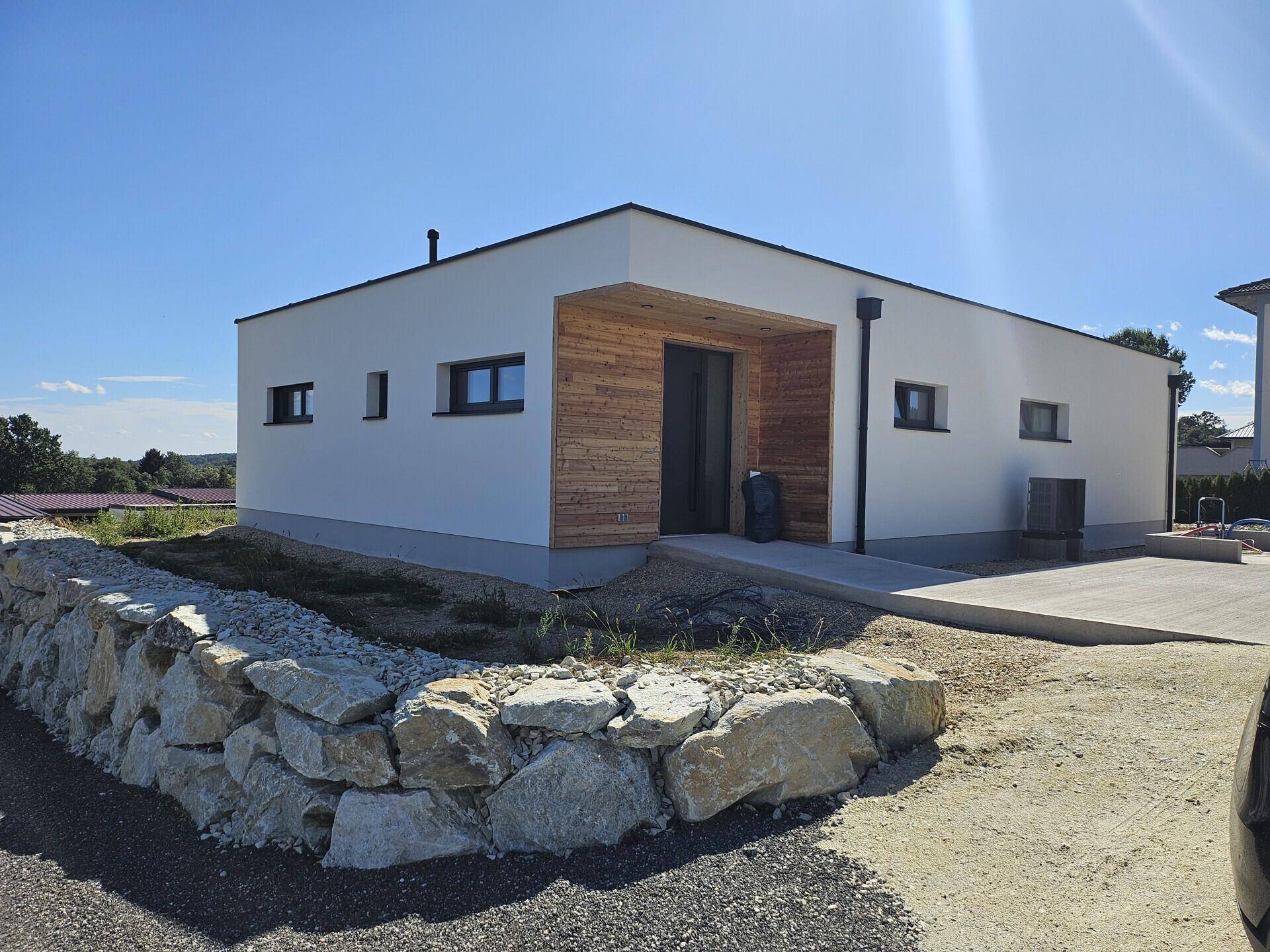 Eingangsbereich des modernen Hauses mit Holzverkleidung und einer barrierefreien Rampe.
