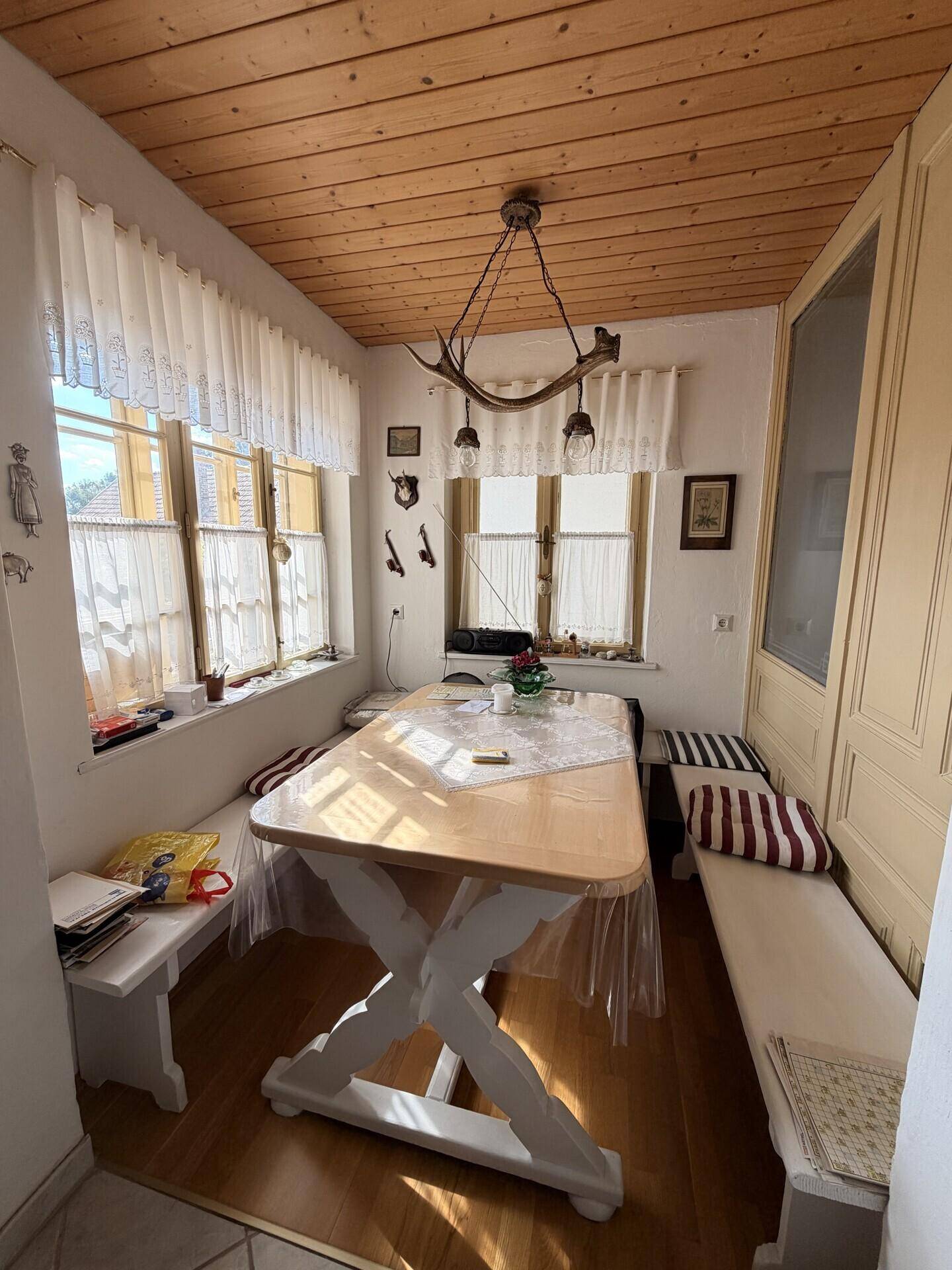 Gemütlicher Essbereich in der Küche mit Holzdecke, Eckbank und traditioneller Dekoration.