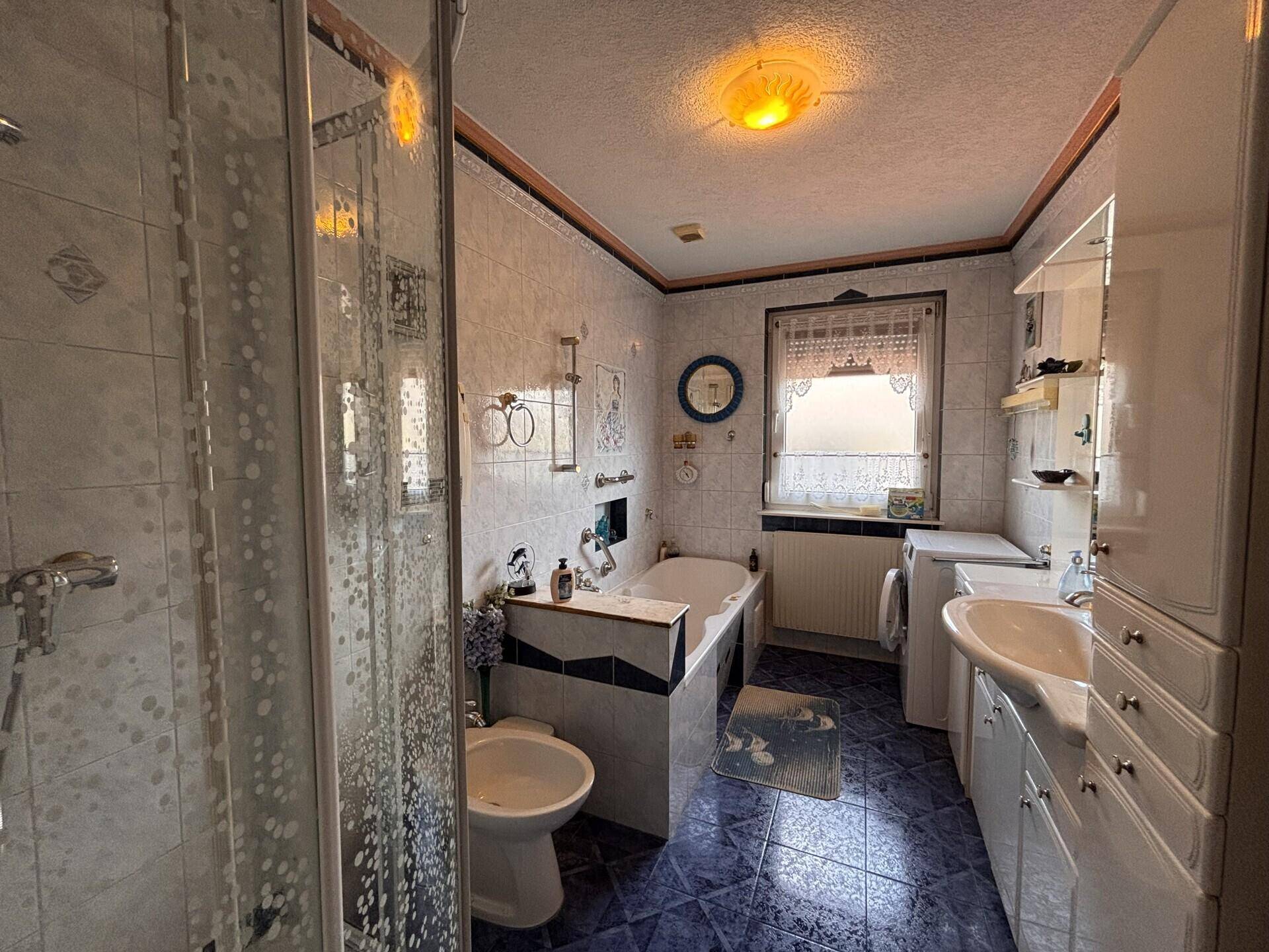 Geräumiges Badezimmer mit Dusche, Badewanne, Bidet und Doppelwaschbecken.