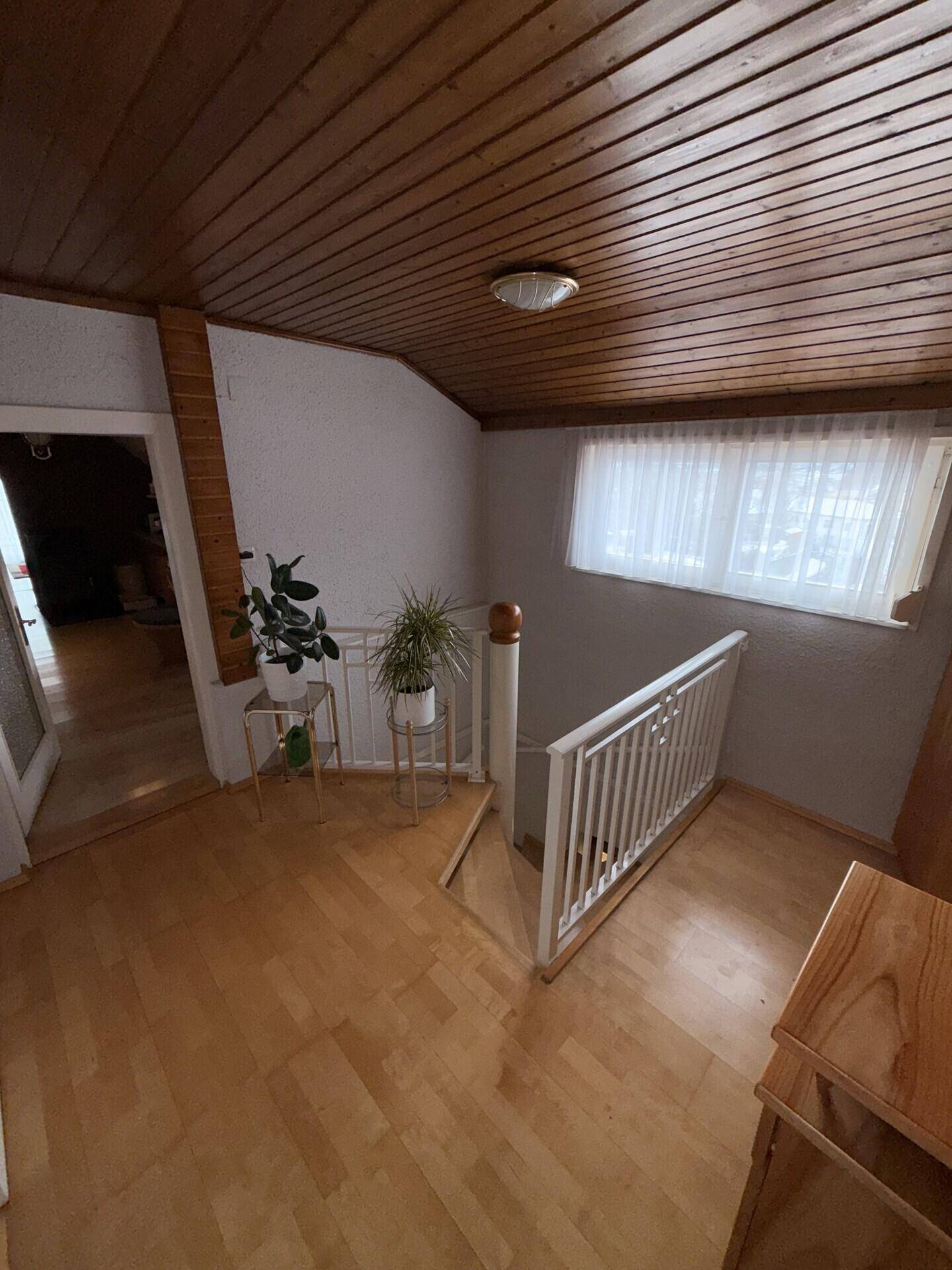 Flur im Obergeschoss mit Holzdecke und Parkettboden, führt zu weiteren Räumen.