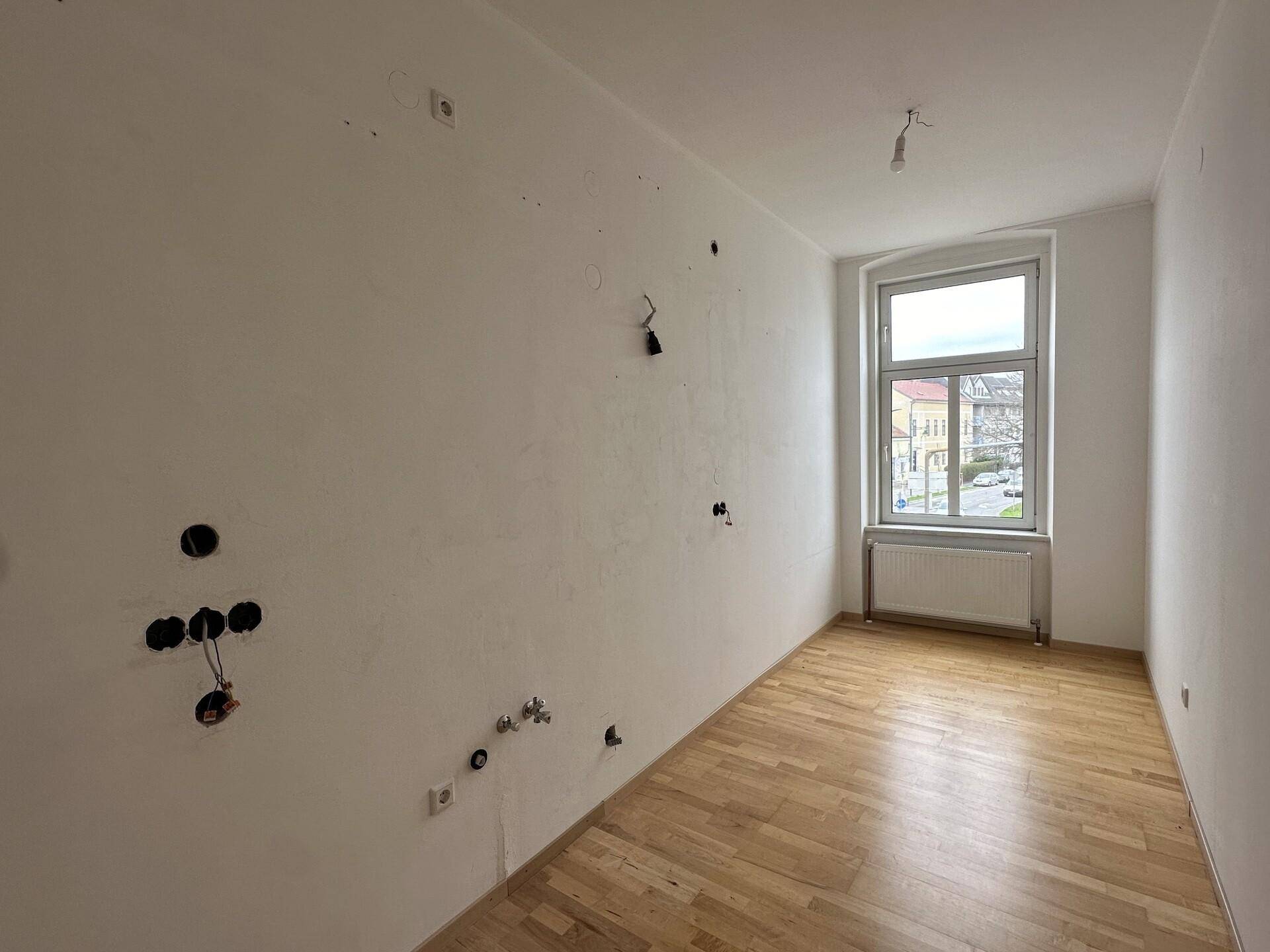 Schlafzimmer mit Parkettboden und Fenster, bereit für individuelle Einrichtung und Gestaltung.