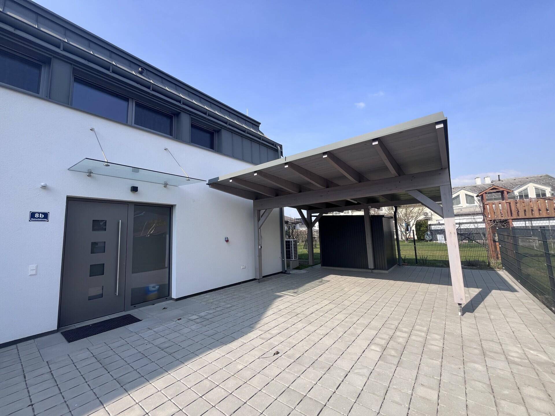 Vorderansicht der Doppelhaushälfte mit Carport und Zugang zum Eingangsbereich.