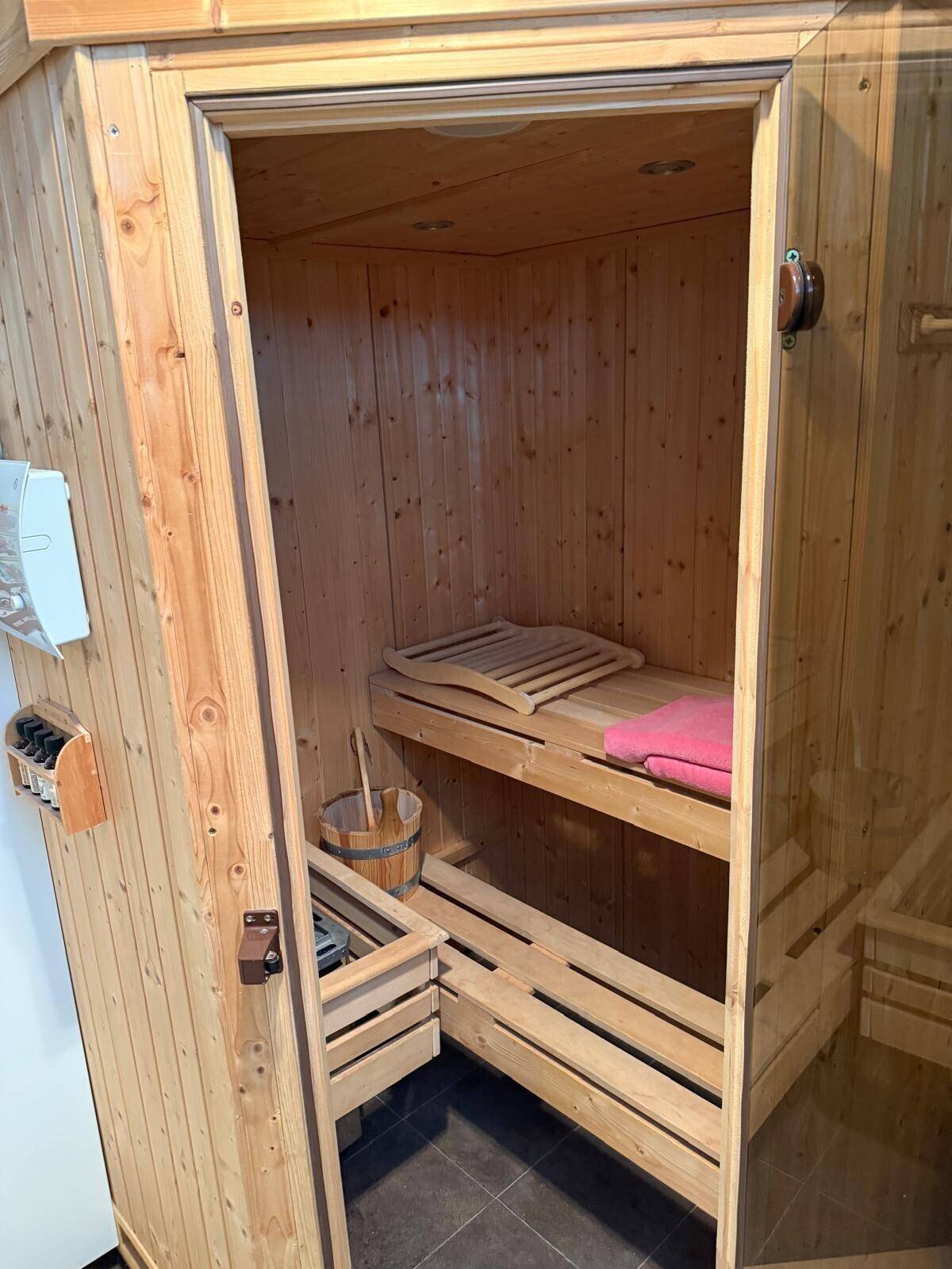 Gemütliche Holzsauna mit Bänken und traditionellem Saunaofen für entspannende Momente.
