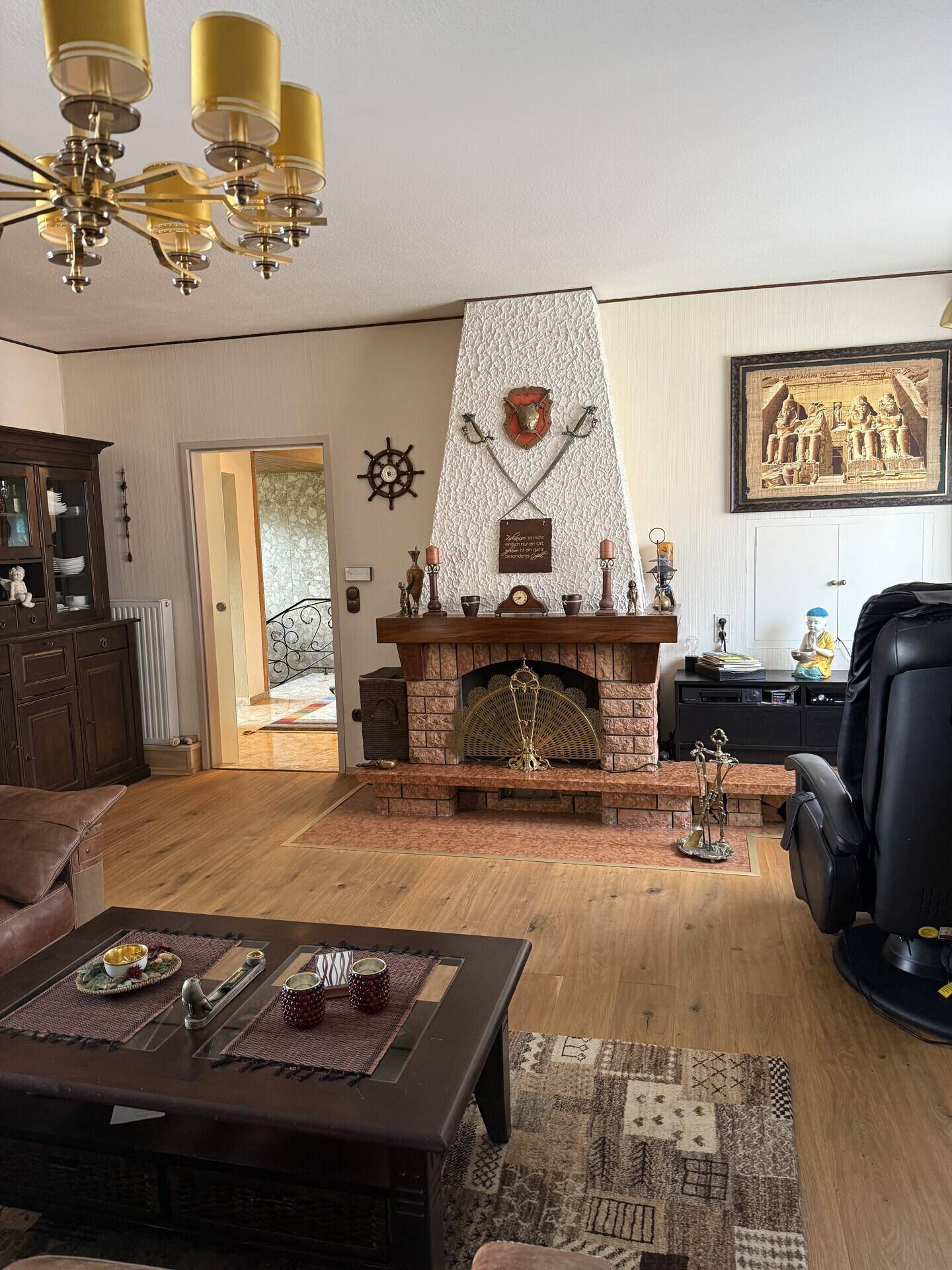 Geräumiges Wohnzimmer mit Kamin, Parkettboden und traditioneller Einrichtung.