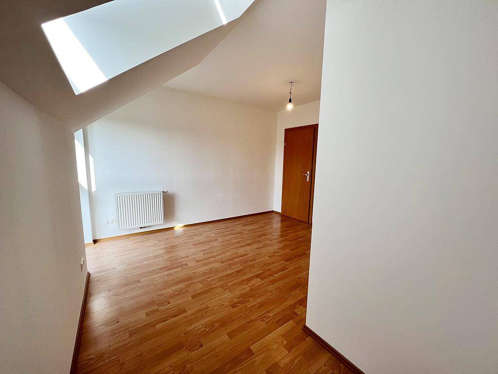 Vielseitig nutzbarer Raum mit Laminatboden und Dachschräge, ideal als Schlaf- oder Arbeitszimmer.