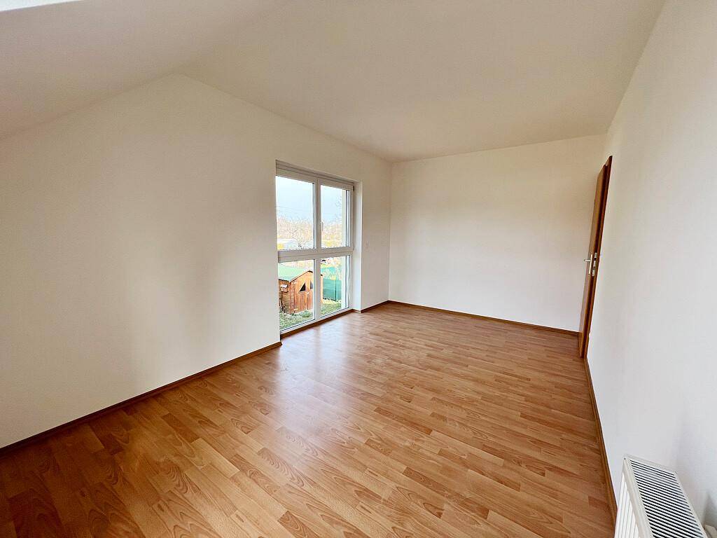 Gemütliches Schlafzimmer mit Laminatboden und Dachschräge, ideal für ein Kinder- oder Gästezimmer.
