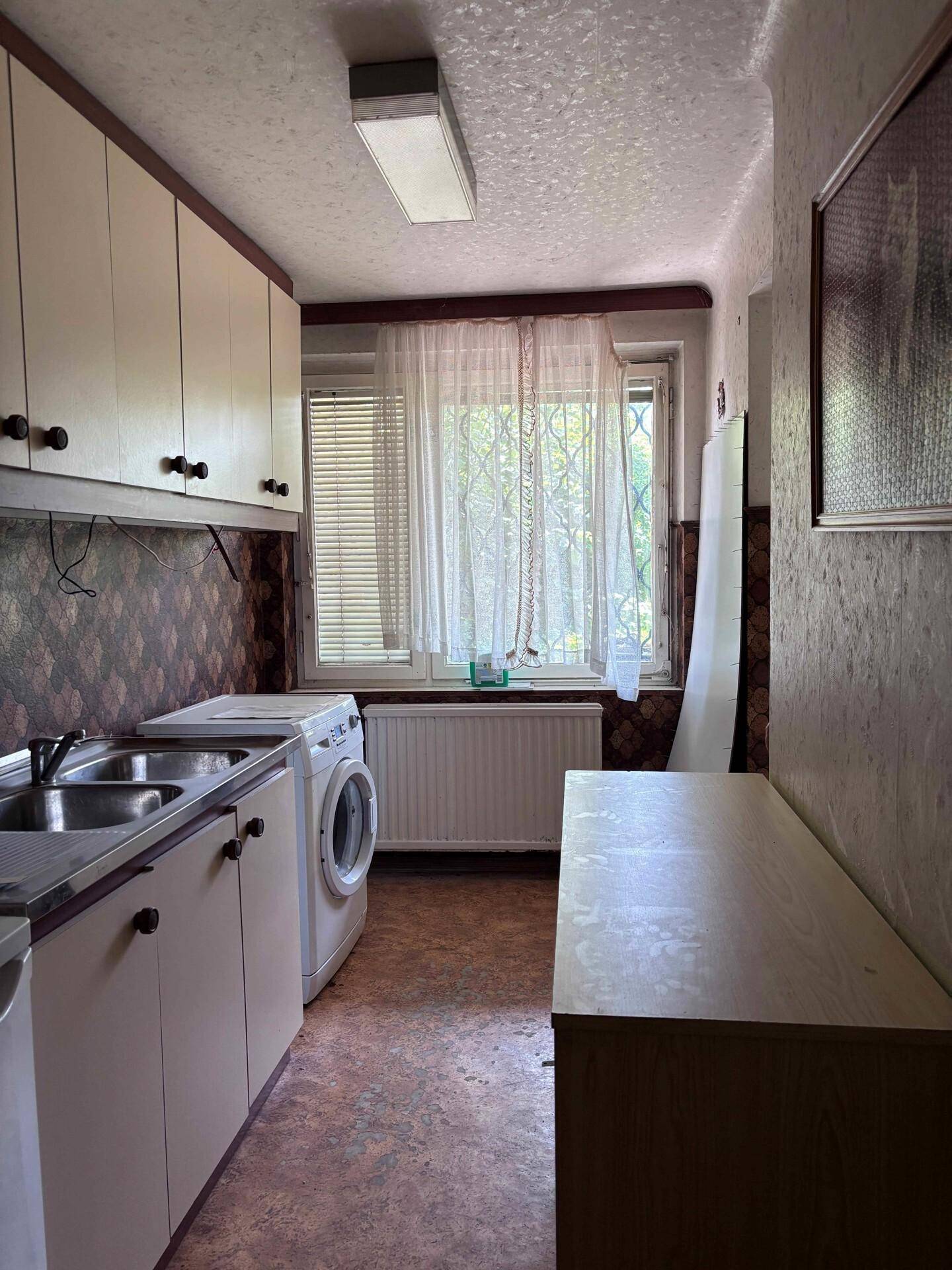 Funktionaler Hauswirtschaftsraum mit Waschmaschine, Spüle und einem Fenster.