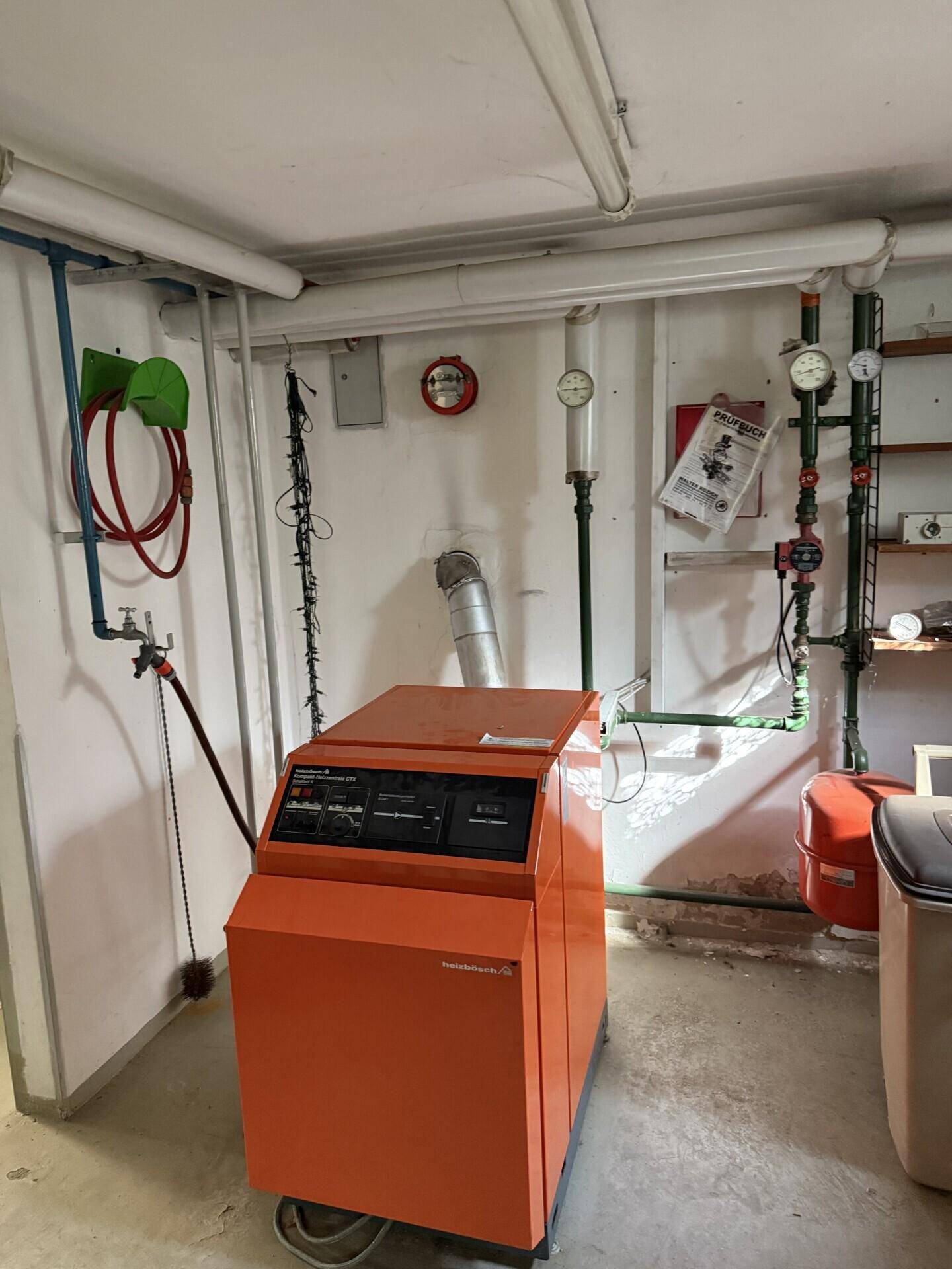Heizraum im Keller mit dem Heizkessel und sichtbaren Rohrleitungen.