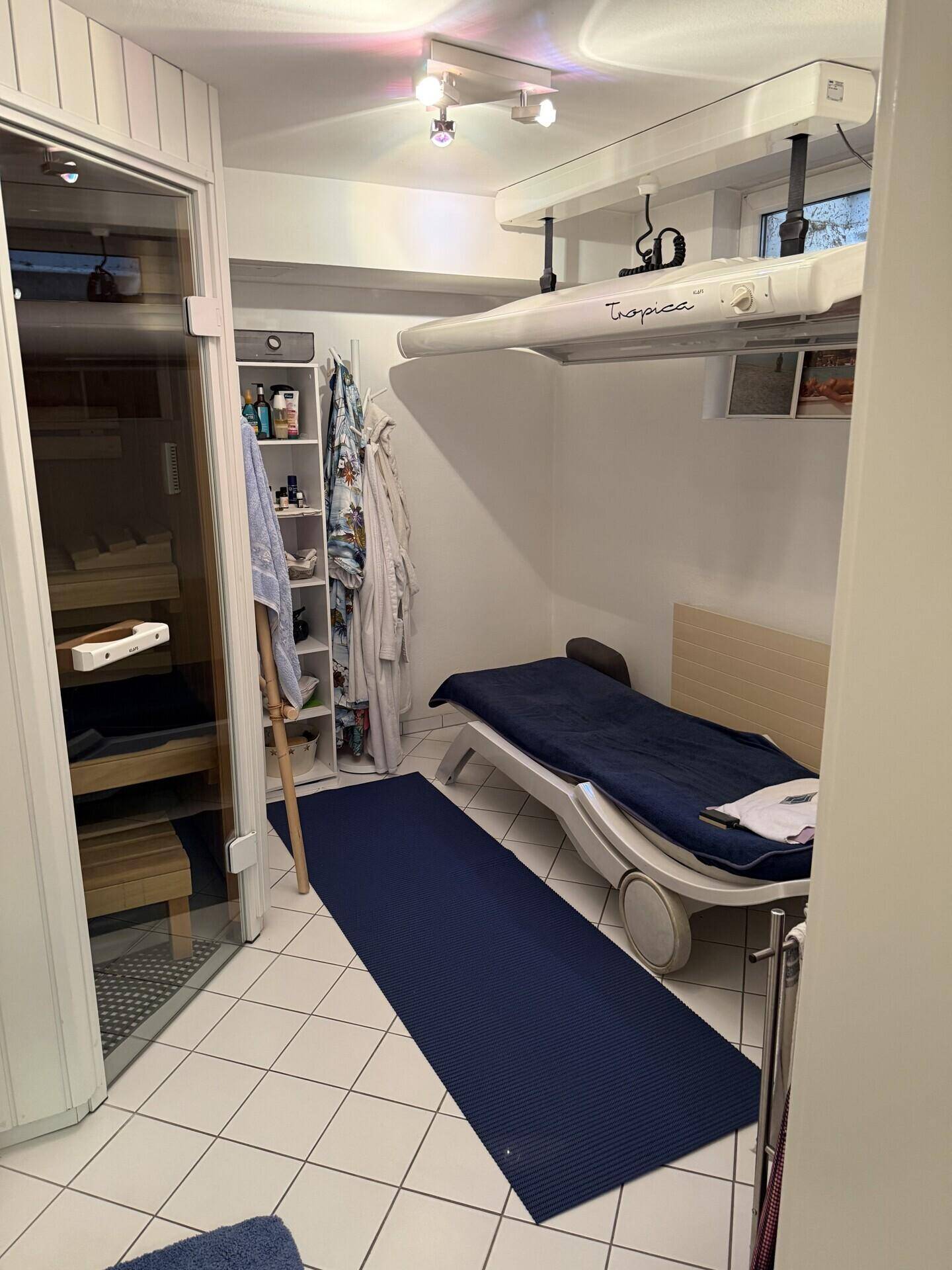 Wellnessbereich mit Solarium, Liege und Zugang zur Sauna.