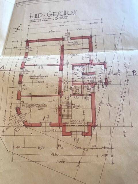 Historischer Grundriss des Erdgeschosses mit verschiedenen Räumen und Treppenhaus.