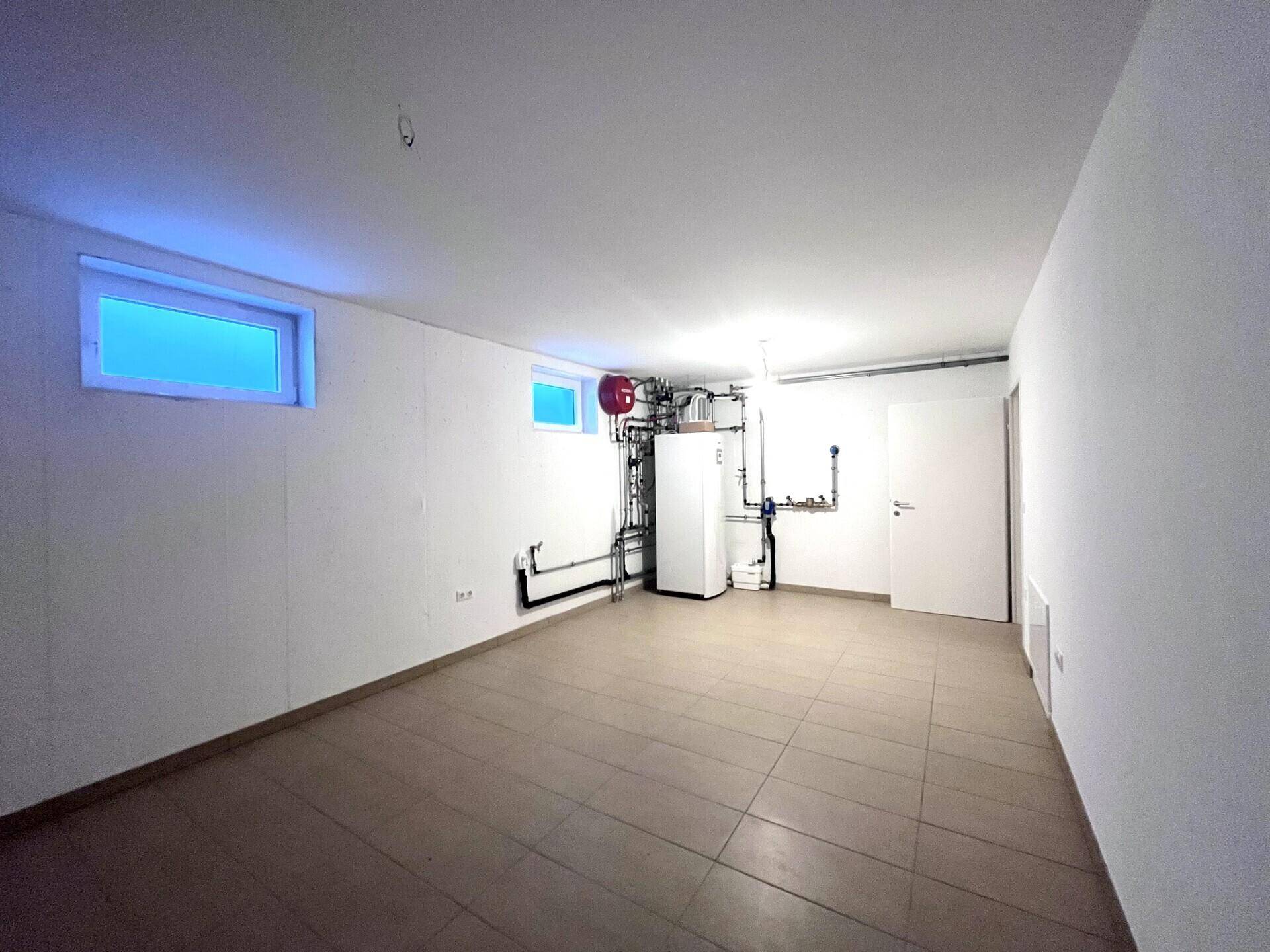 Technikraum im Keller mit Heizungsanlage und weiteren Installationen.