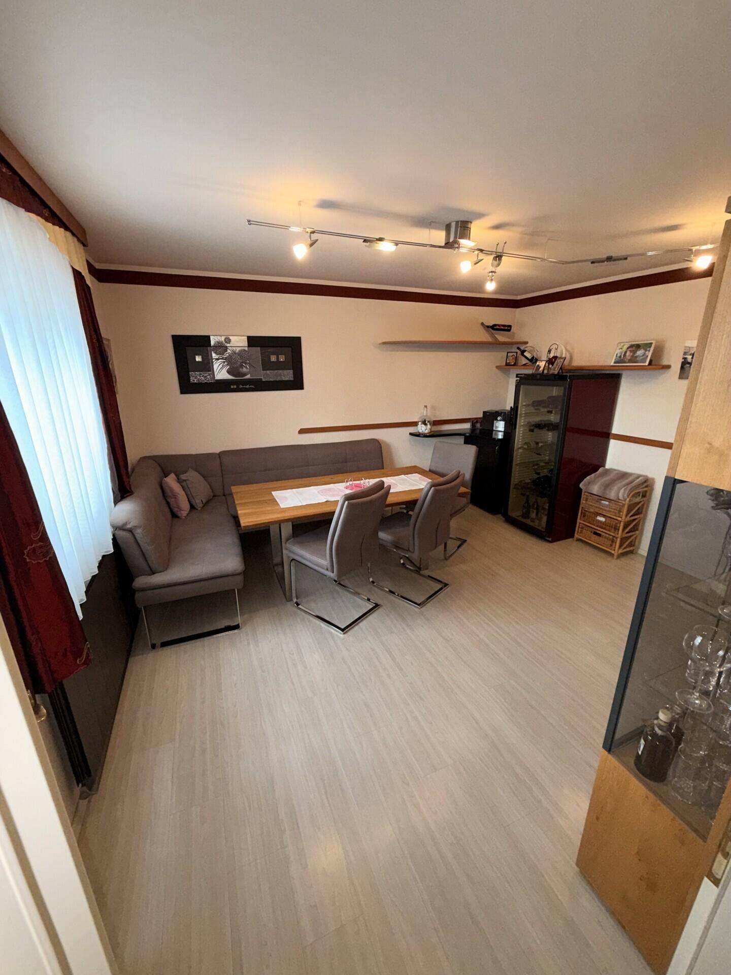 Essbereich mit Eckbank, Holztisch und Laminatboden in traditionellem Stil.