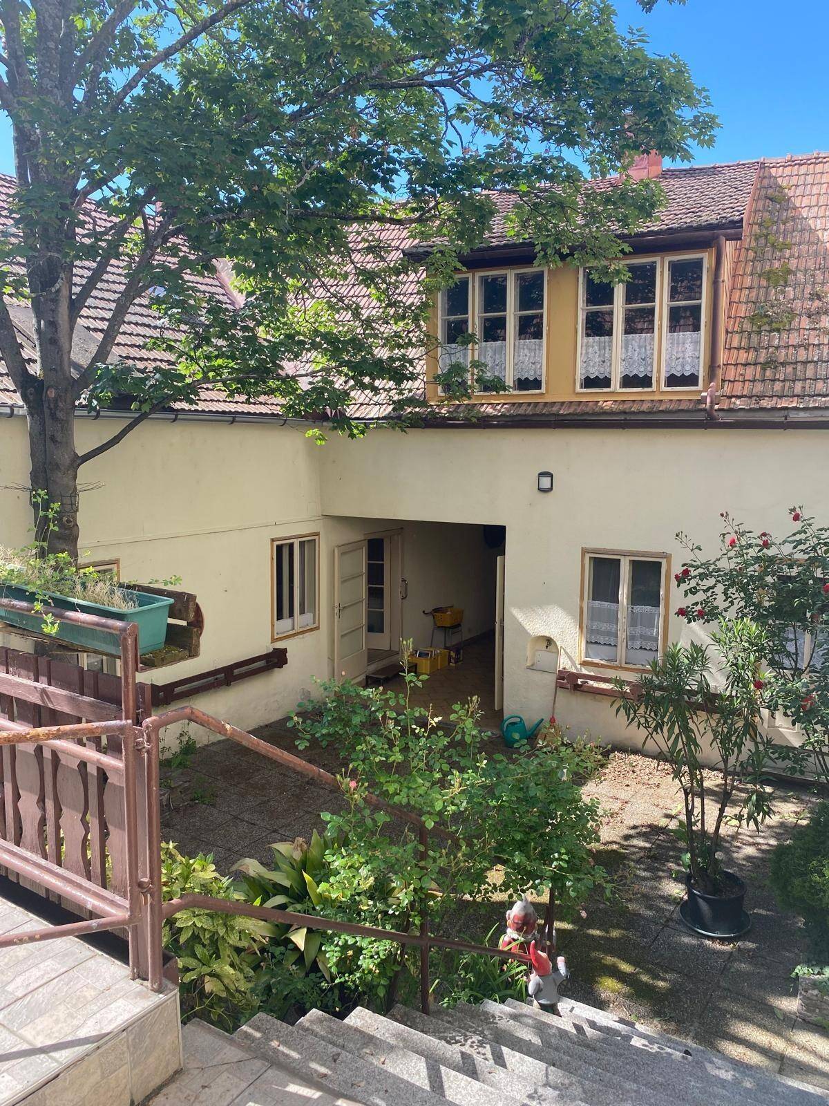 Blick auf den Innenhof mit einem weiteren Gebäudeteil und einem kleinen Gartenbereich.