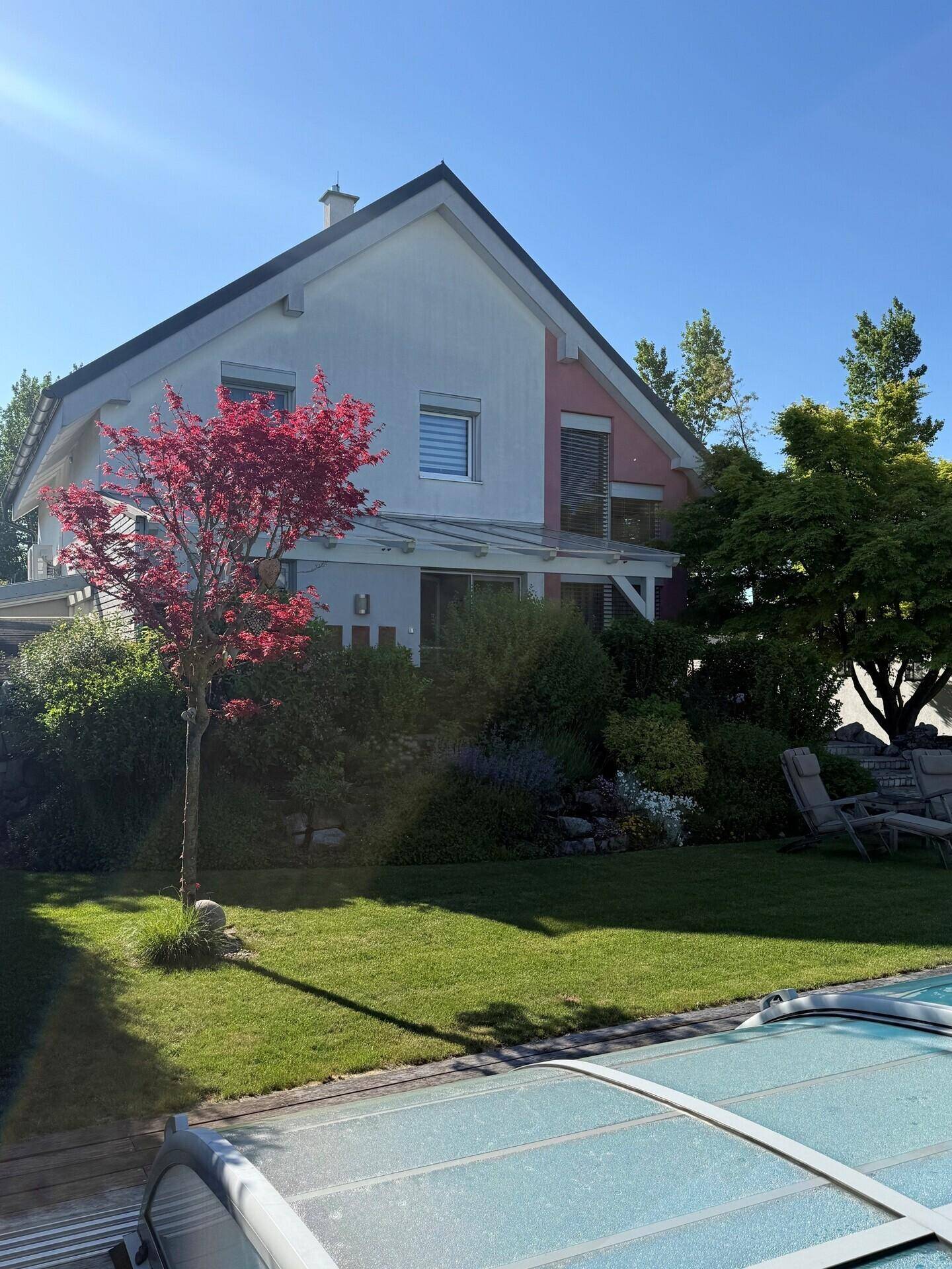 Ansicht des Hauses vom Garten aus mit gepflegter Fassade und üppiger Bepflanzung.