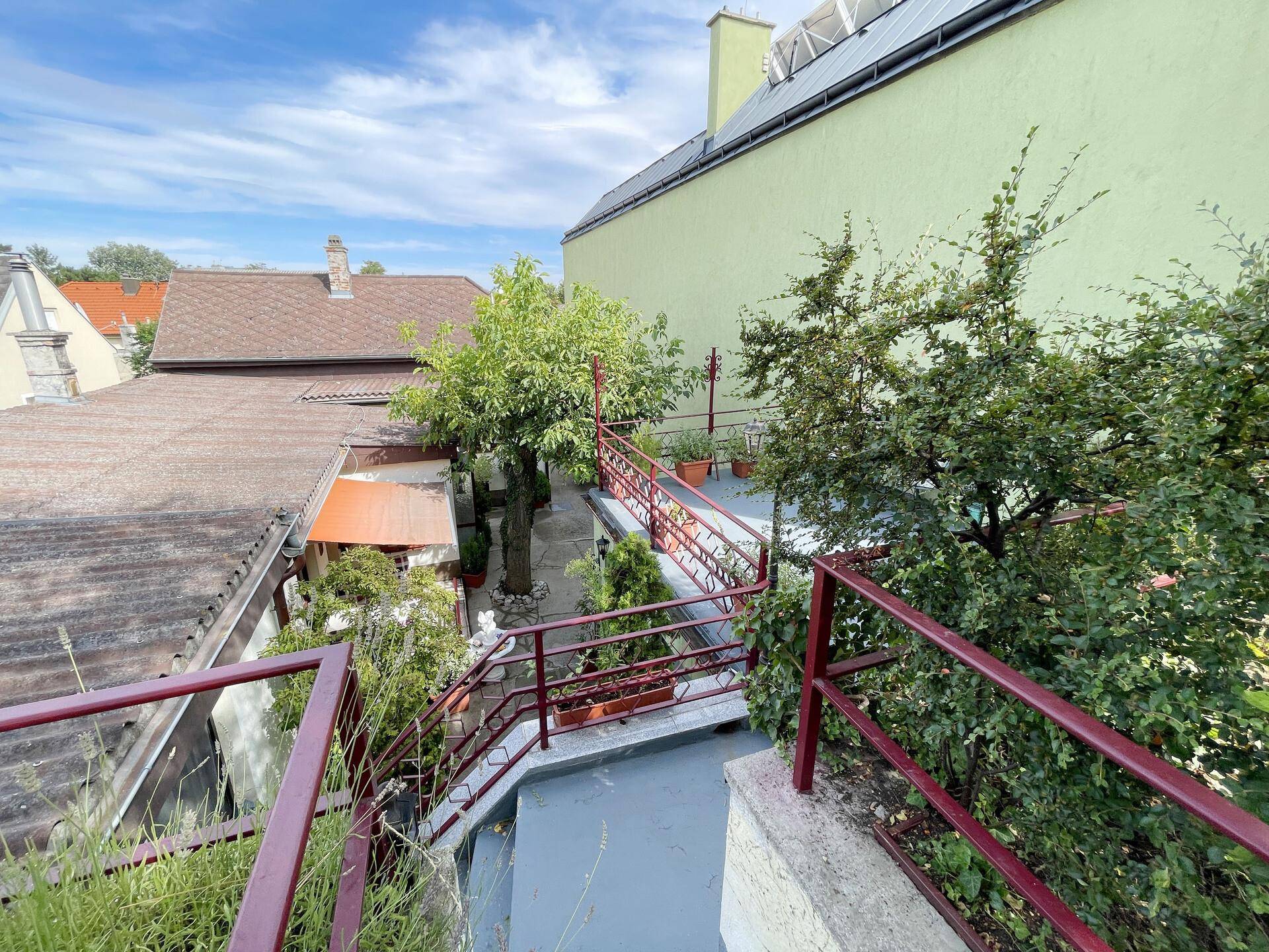 Terrasse mit Treppenzugang zum unteren Bereich und Blick auf die umliegenden Häuser.