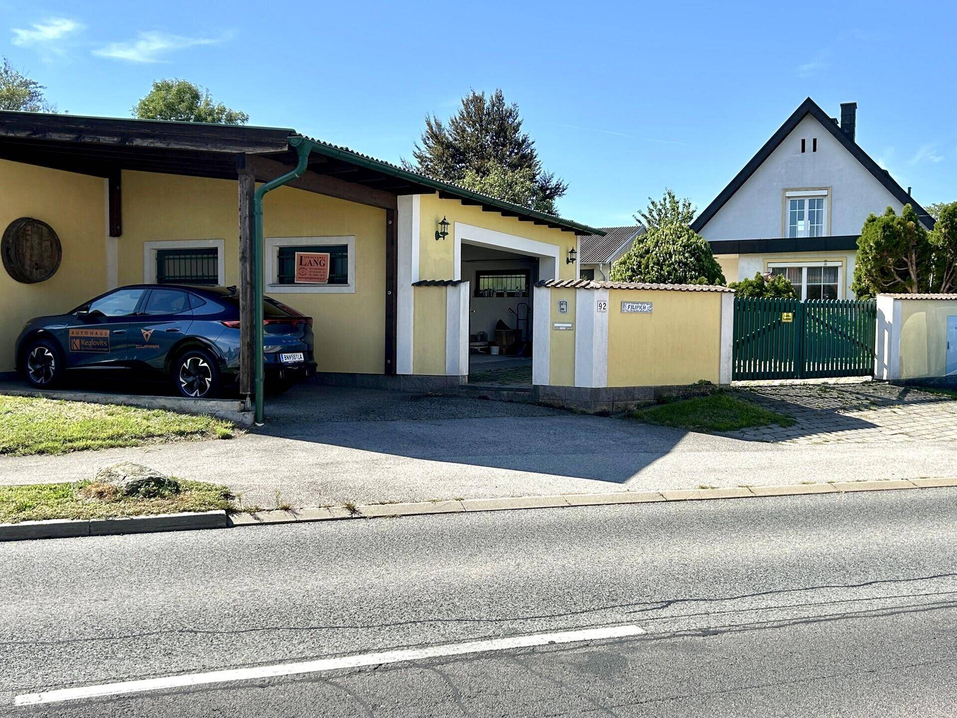 Straßenansicht des Anwesens mit Einfamilienhaus, Garage und Zufahrt.