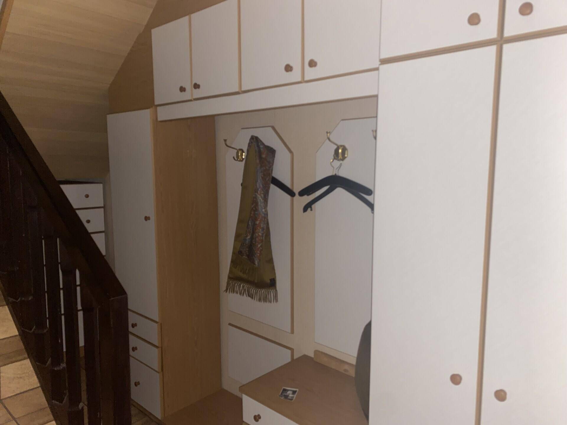 Eingangsbereich mit Einbauschränken, Garderobe und Treppenaufgang.