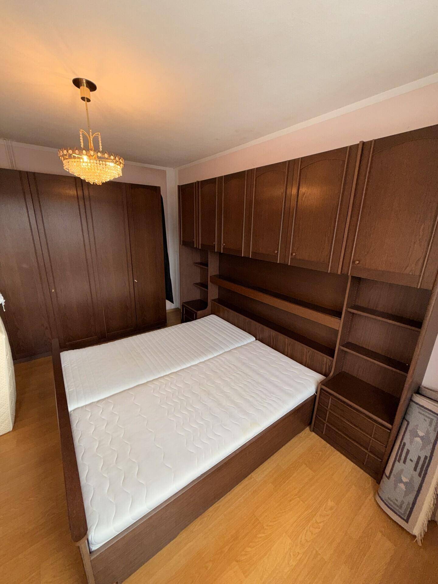 Schlafzimmer mit Einbauschränken aus Holz und Doppelbett in traditionellem Stil.