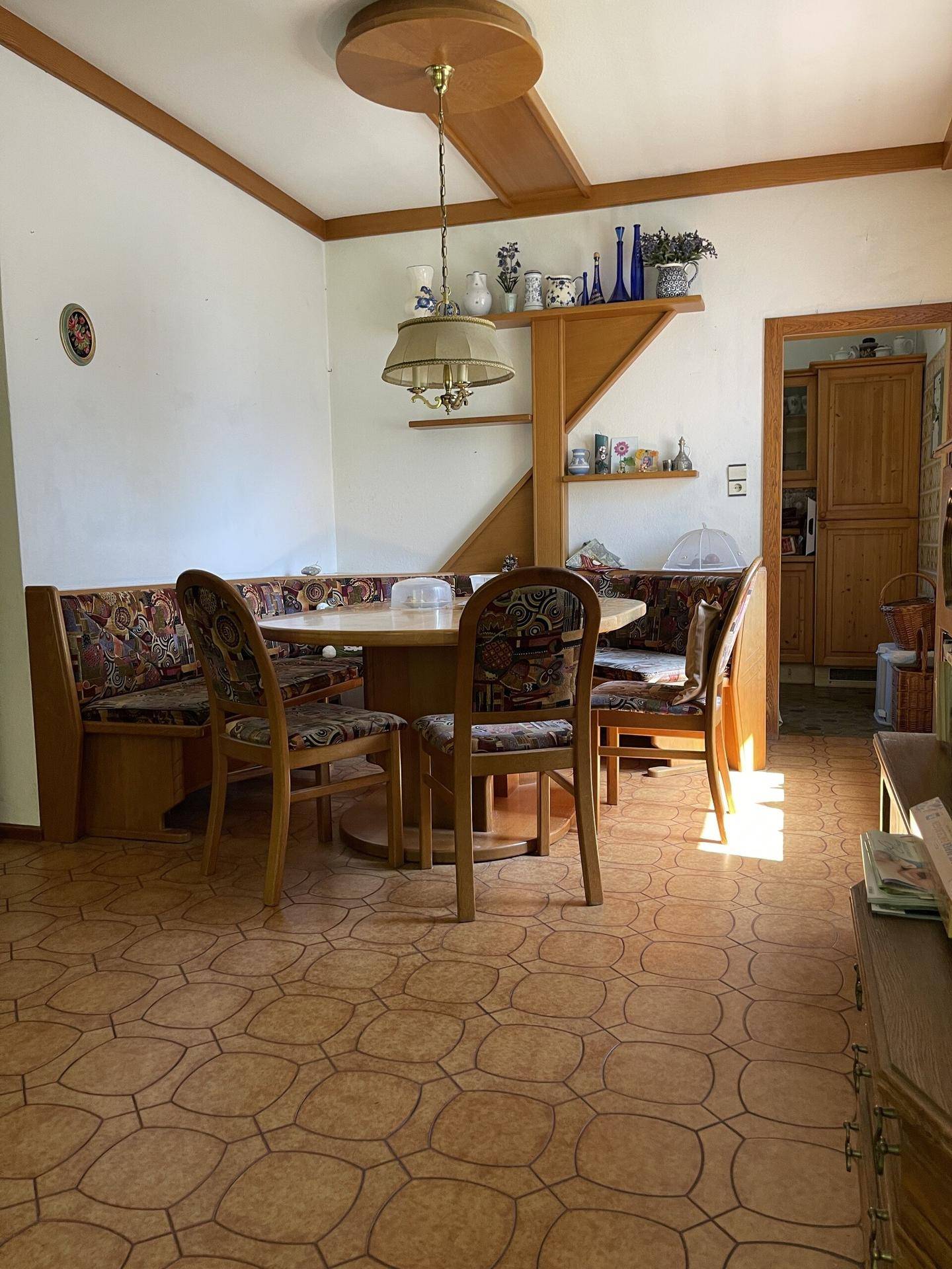 Gemütlicher Essbereich mit Eckbank, Holztisch und traditionellem Fliesenboden.