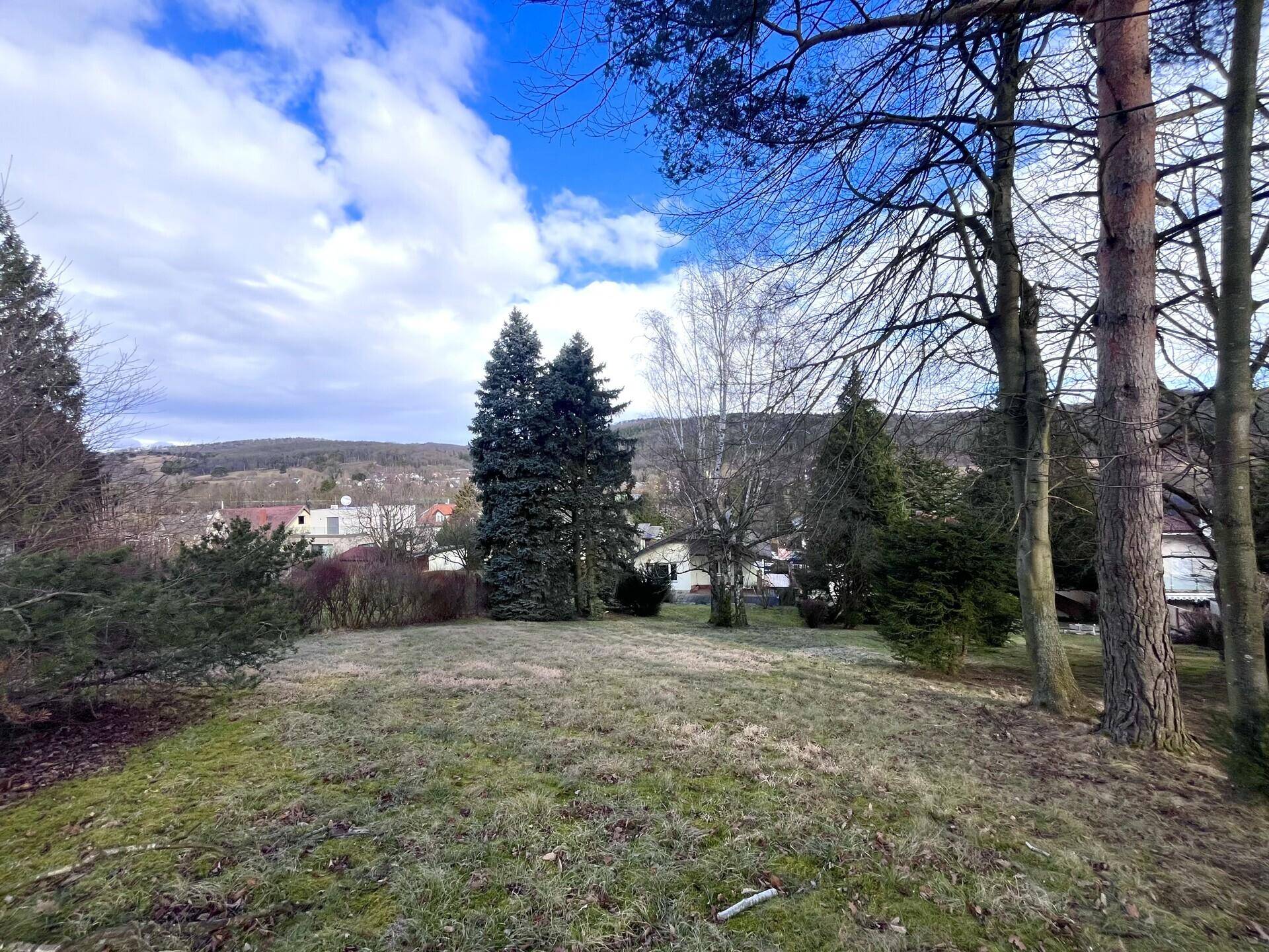 Garten mit Bäumen und Panoramablick auf die umliegende Landschaft und Siedlung.