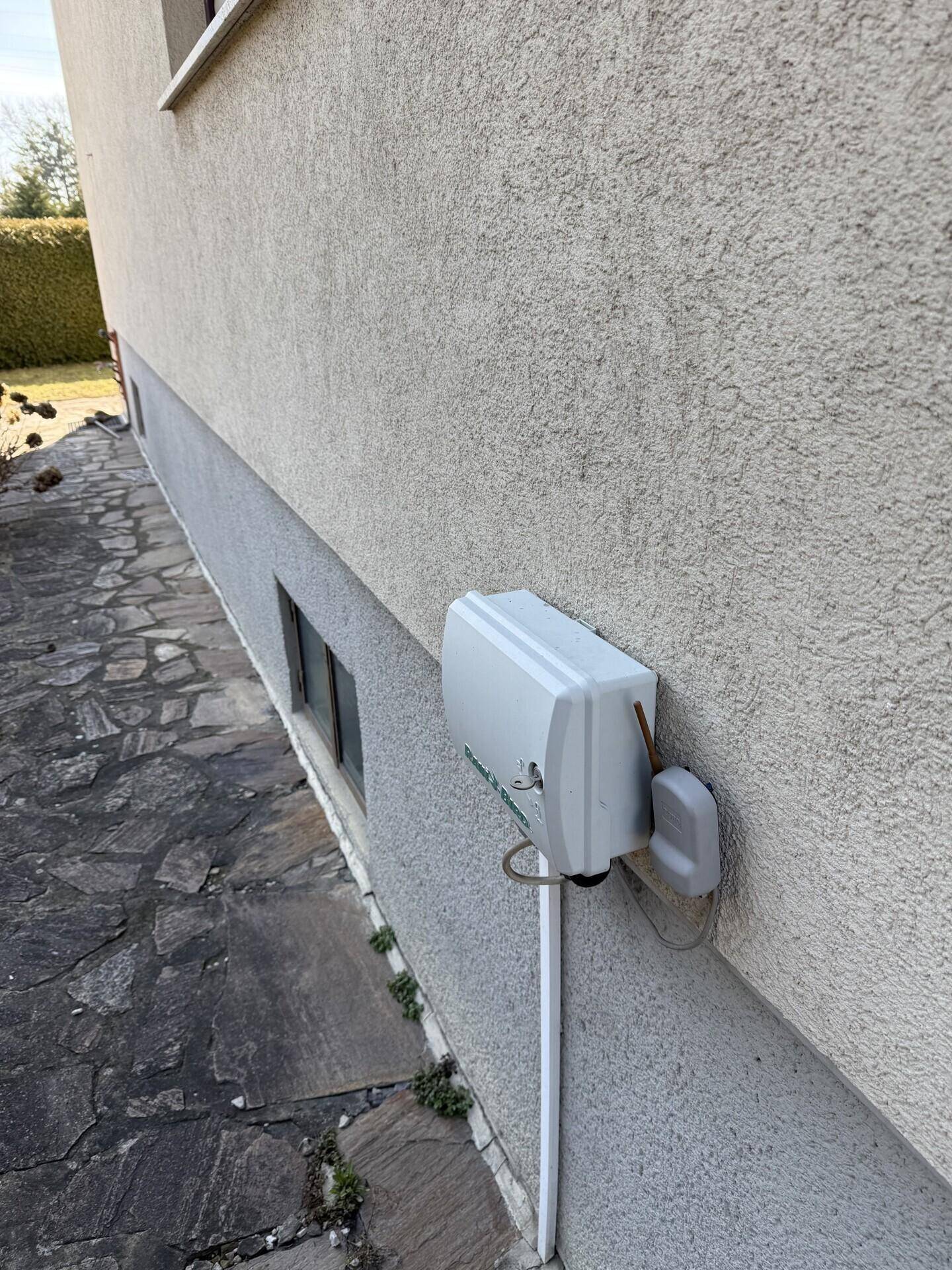 Außenwand des Hauses mit einem angebrachten Versorgungsanschlusskasten.