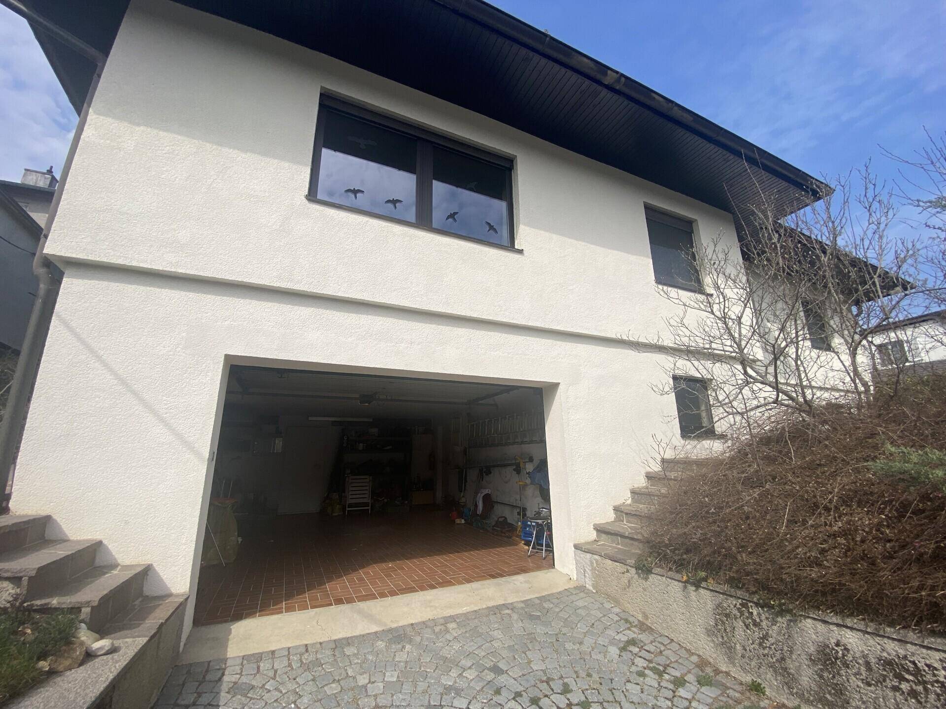 Vorderansicht des Hauses mit integrierter Garage und Außentreppe.