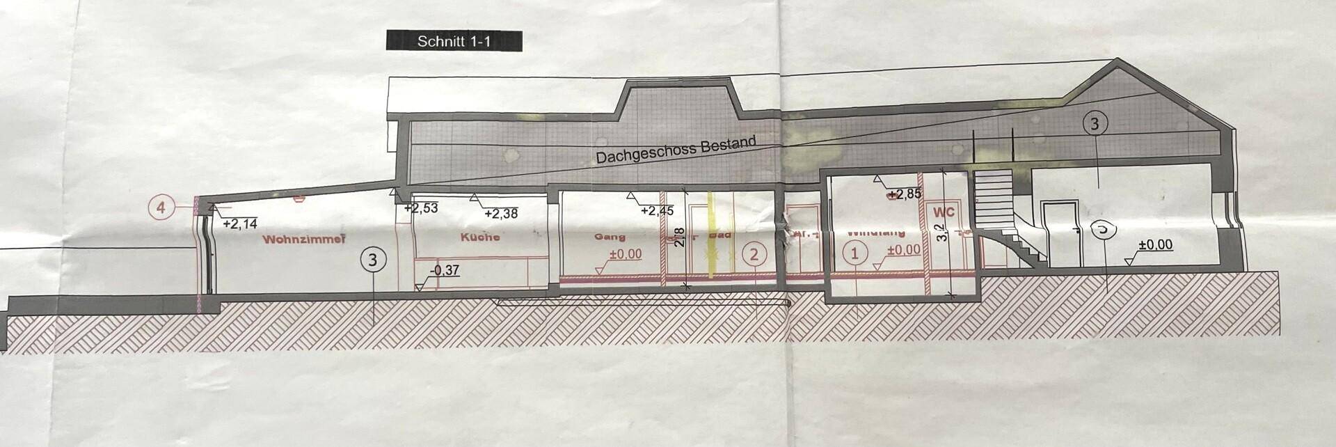 Schnittzeichnung des Gebäudes mit Wohnzimmer, Küche und WC auf verschiedenen Ebenen.