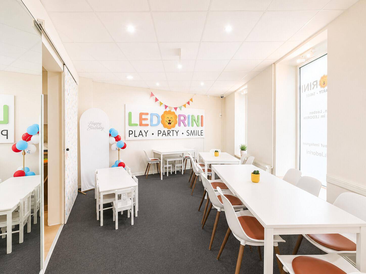 Heller Veranstaltungsraum mit mehreren Tischen und Stühlen, ideal für Kinderpartys und Feiern.
