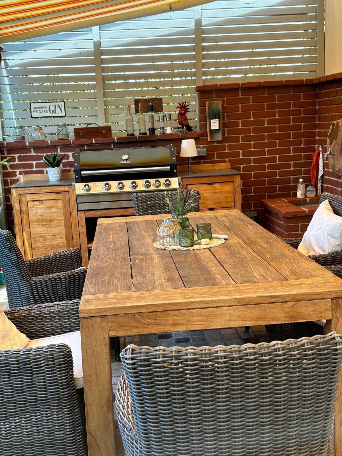 Gemütlicher Außenbereich mit integrierter Grillstation und Esstisch, perfekt für Sommerabende.
