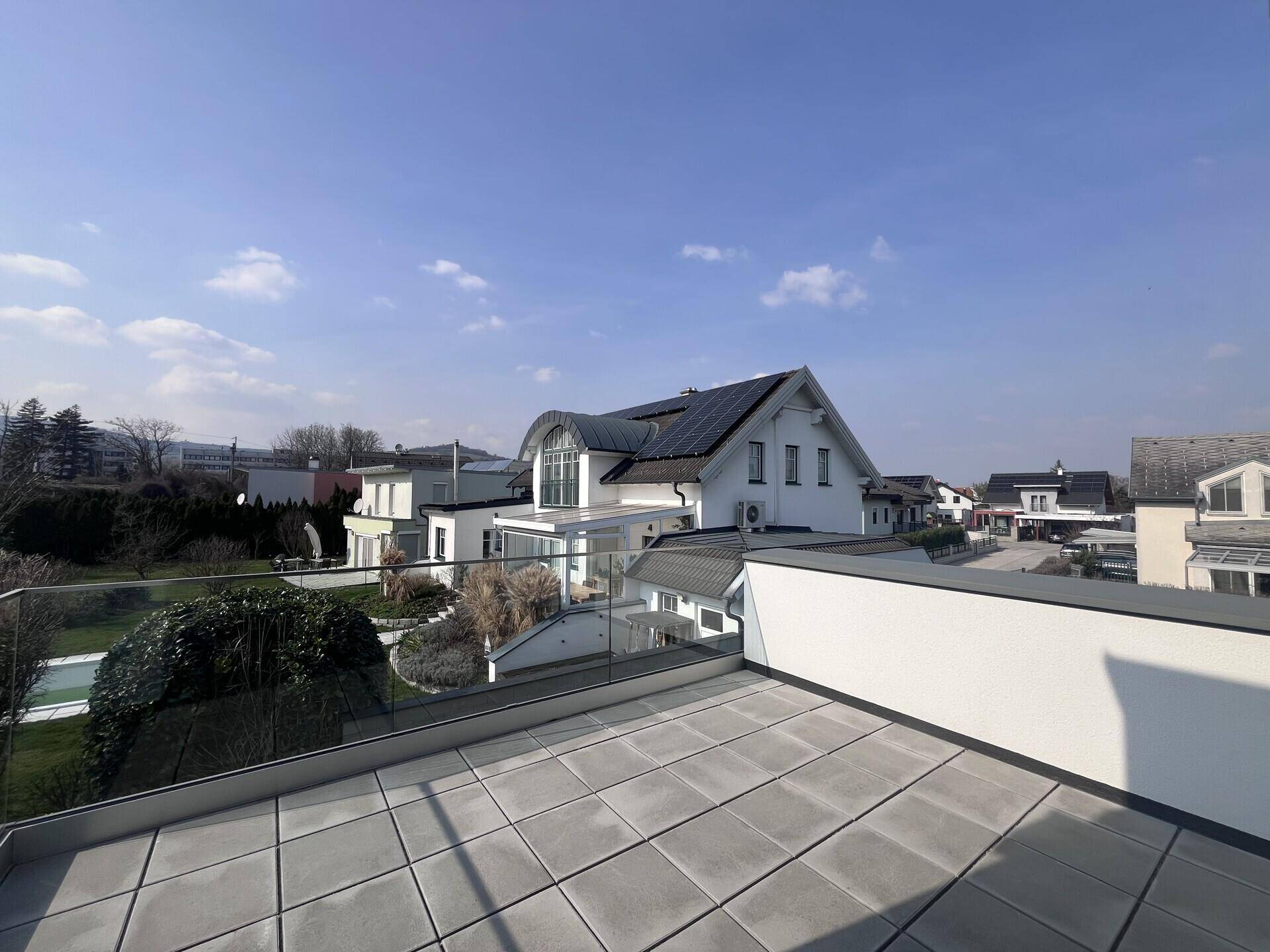 Große Dachterrasse mit Fliesenboden und weitem Blick über die Nachbarschaft.